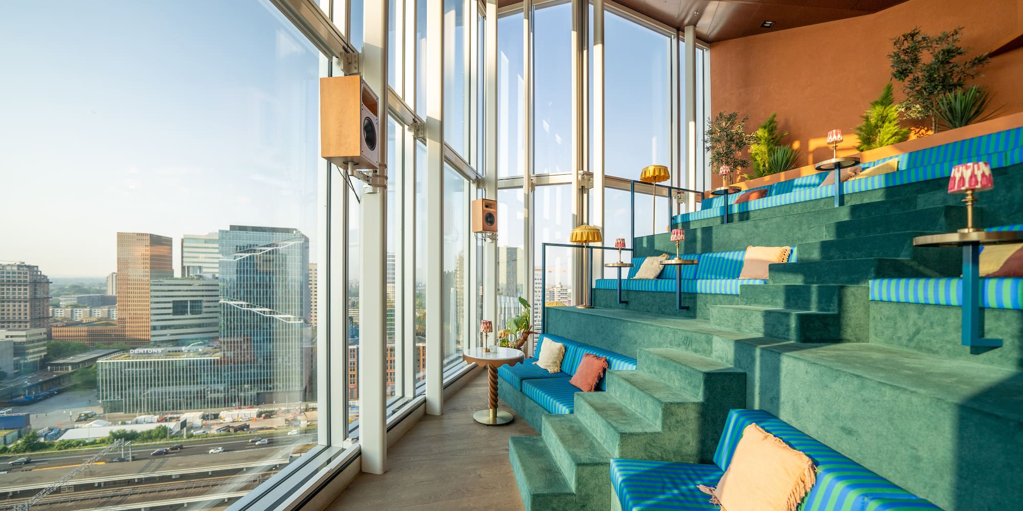 a blue and green seats in a room with large windows