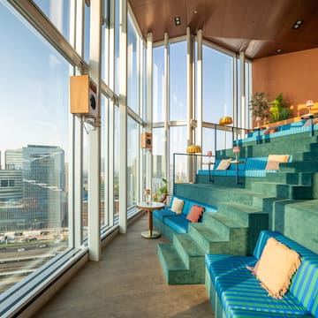 a blue and green seats in a room with large windows