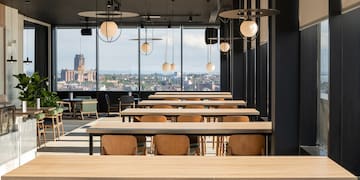 a room with tables and chairs and a view of a city