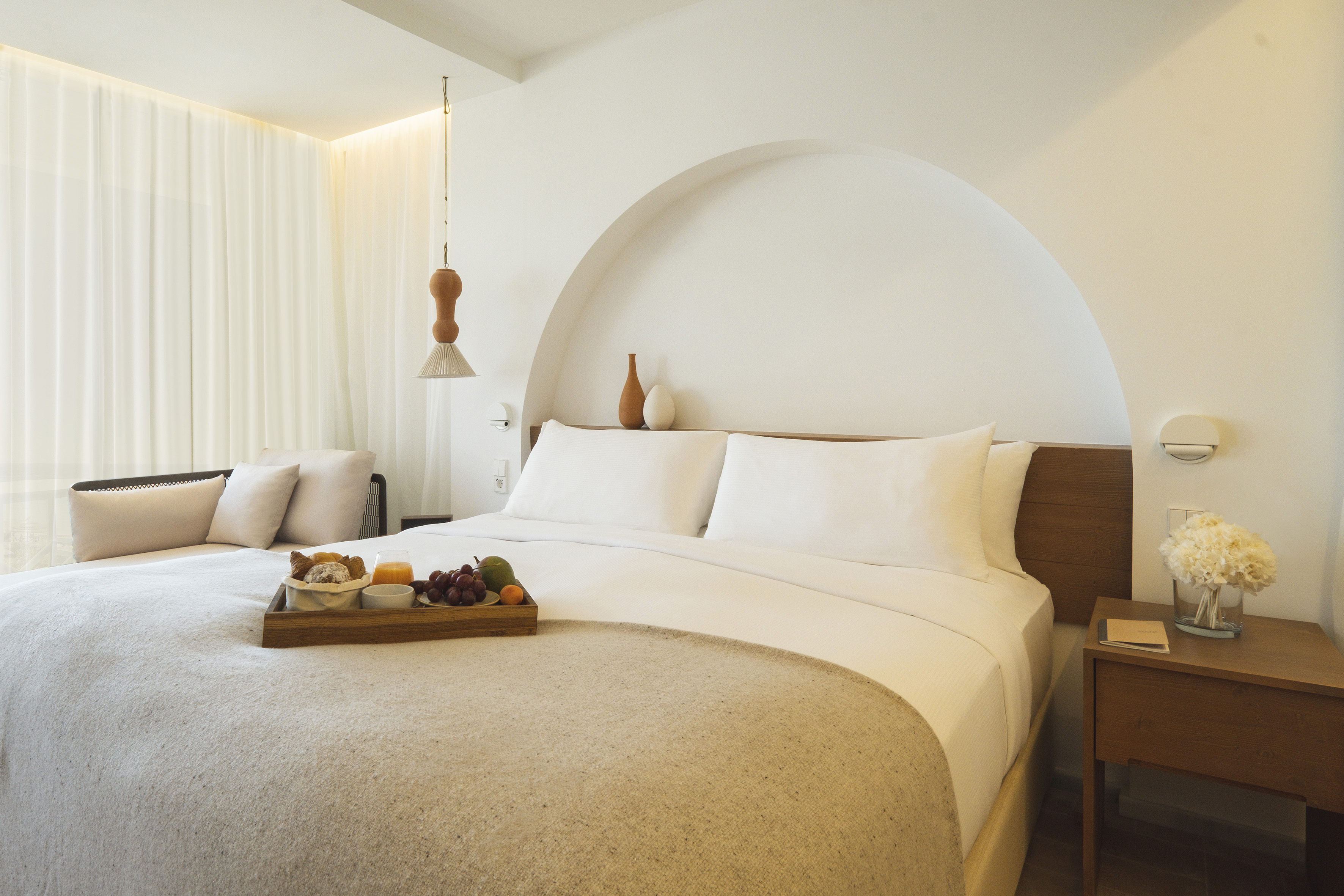 a bed with a tray of fruit on it
