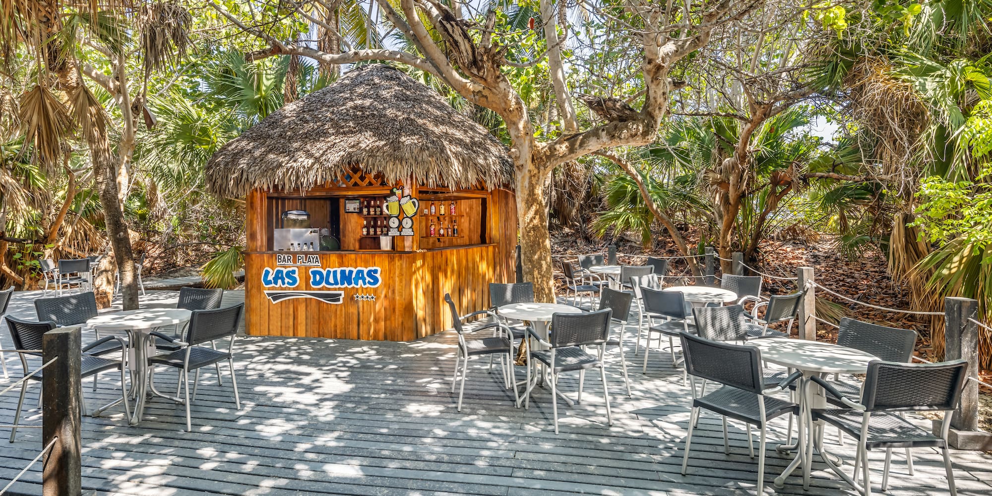 a hut with tables and chairs on a deck