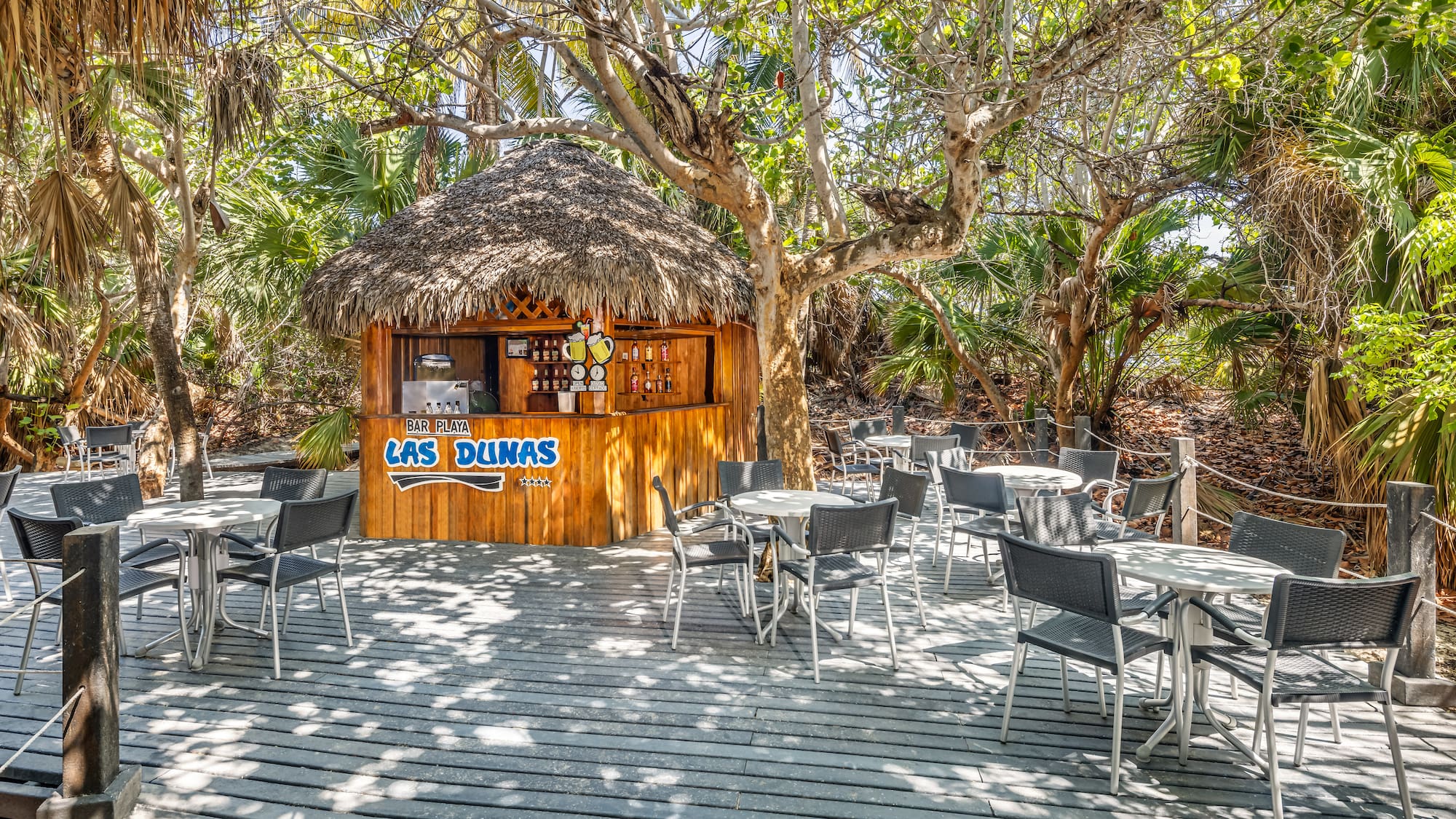 a hut with tables and chairs on a deck