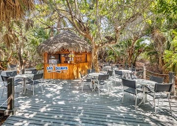 a hut with tables and chairs on a deck