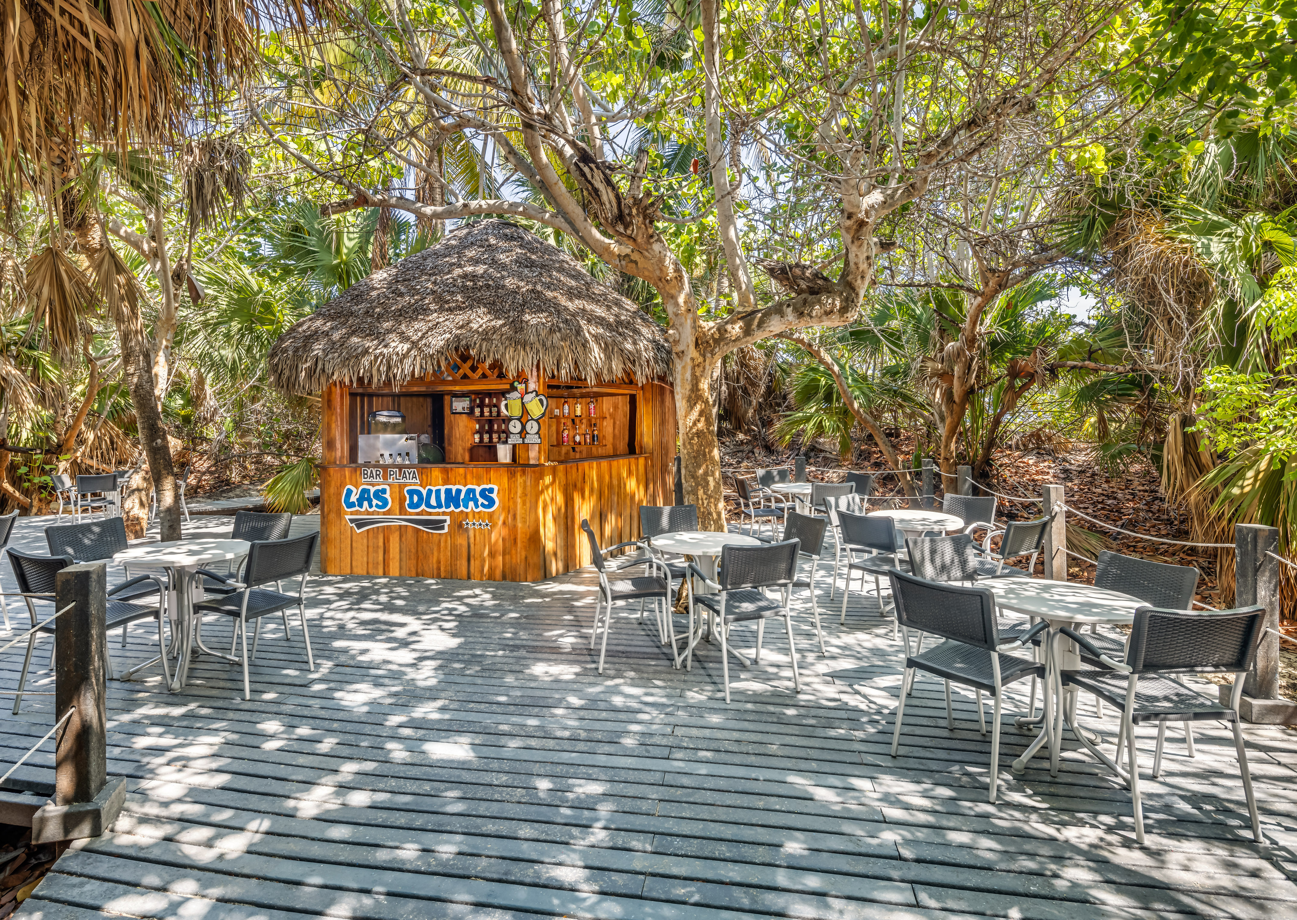 a hut with tables and chairs on a deck