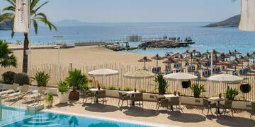 a pool with umbrellas and chairs on a beach