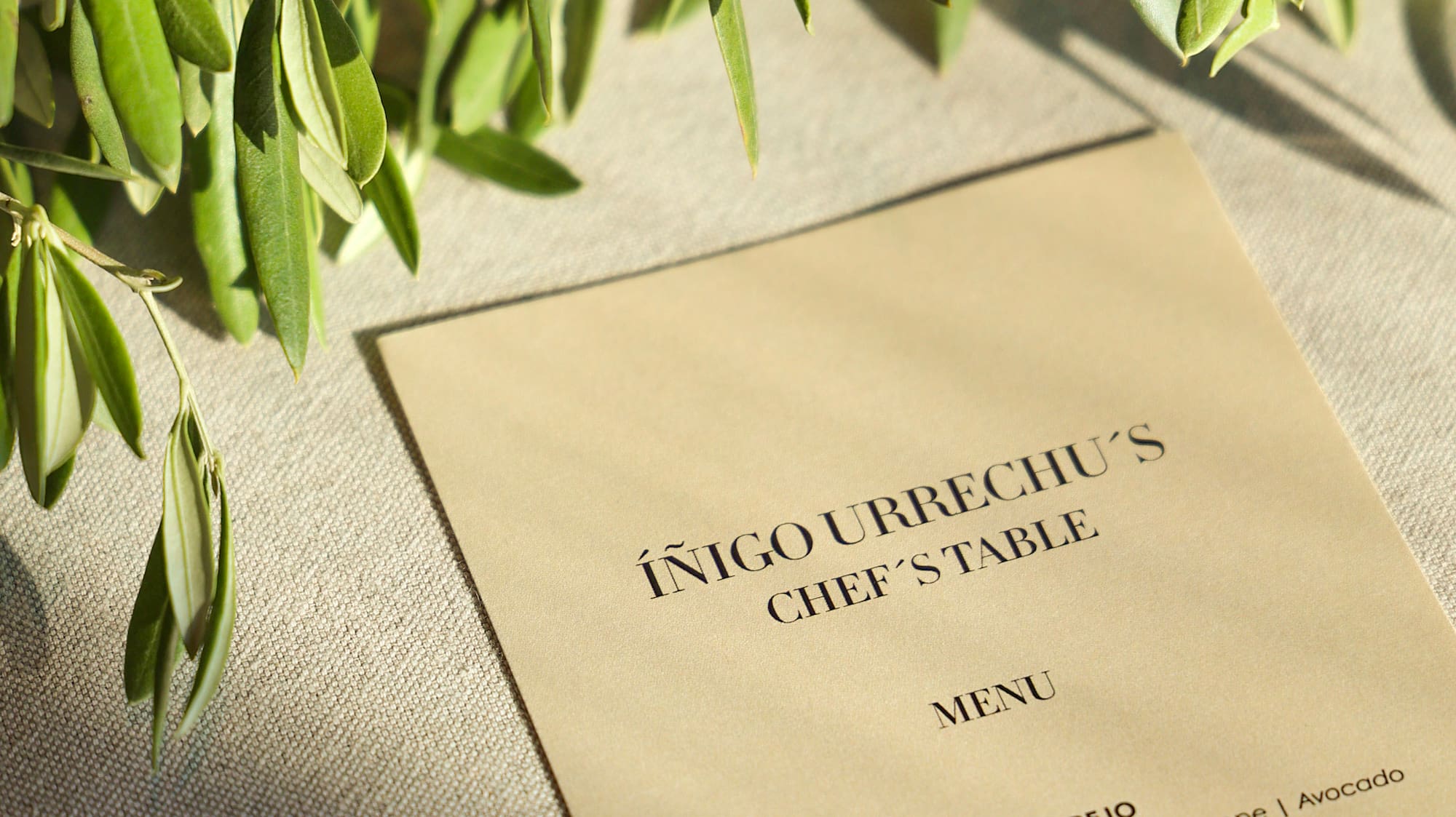 Íñigo Urrechu's Chef's Table menu, featuring an olive branch and sunlight.