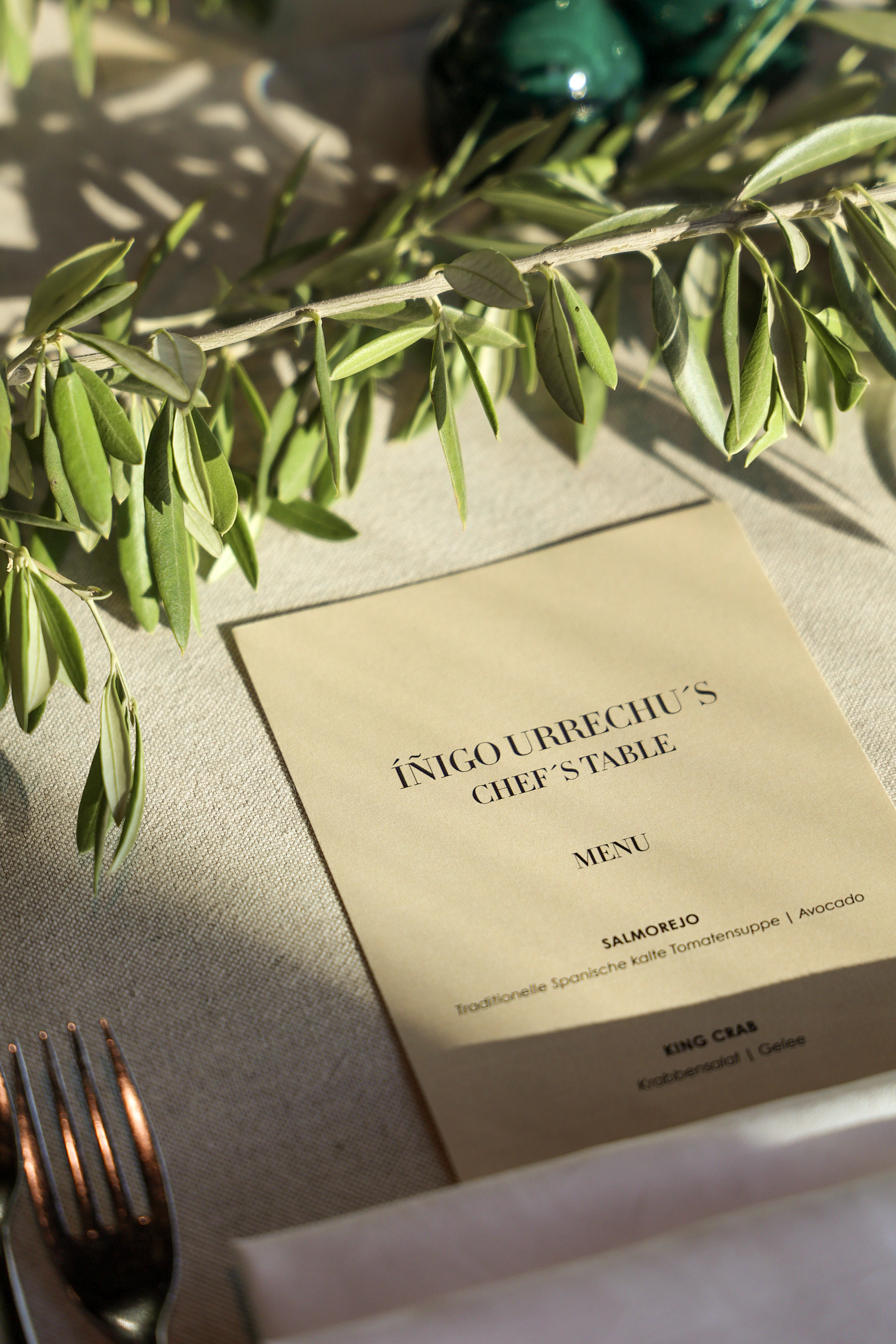 Íñigo Urrechu's Chef's Table menu, featuring an olive branch and sunlight.