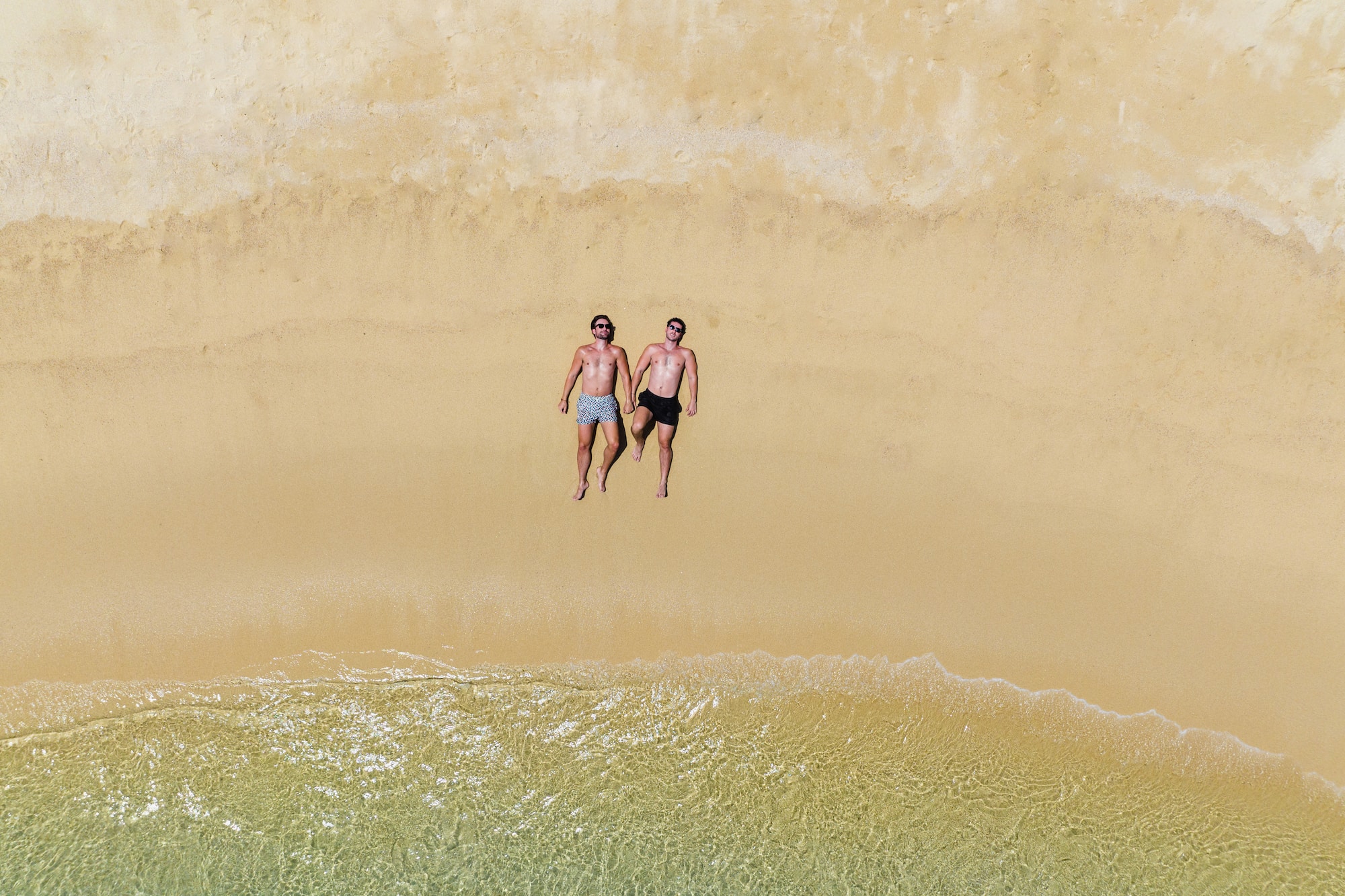 two men lying on a beach
