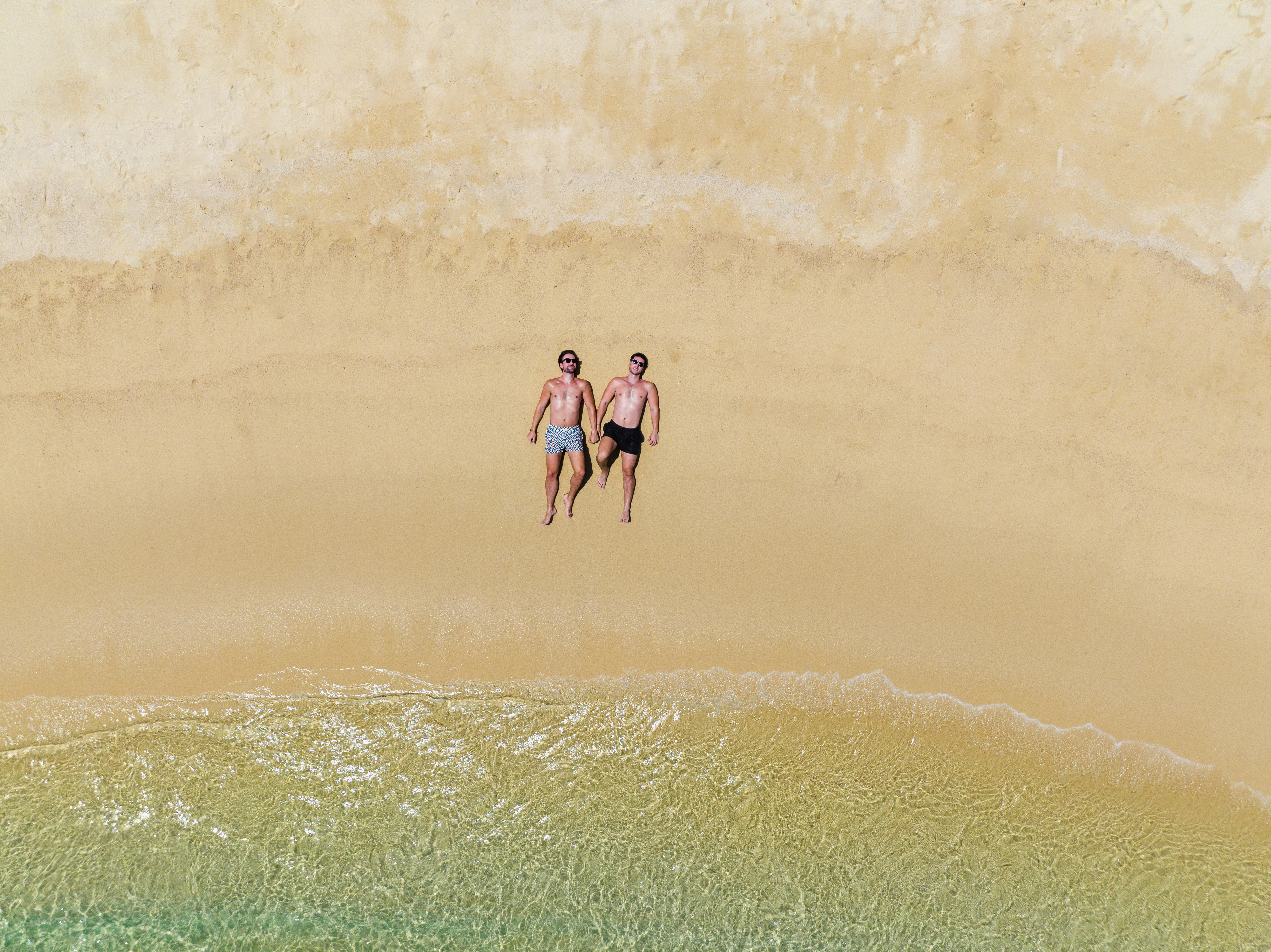 two men lying on a beach