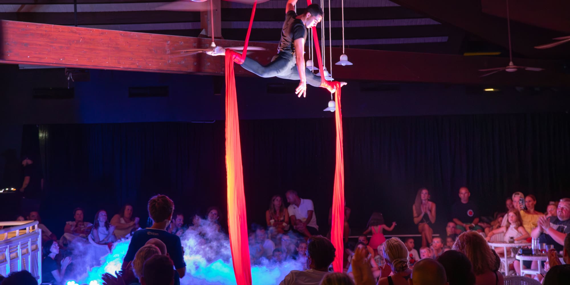 a man on a stage with red ribbons