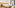 Bright hotel room with double bed, wood headboard, nightstands, balcony view.