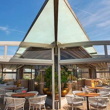 a glass roof with tables and chairs