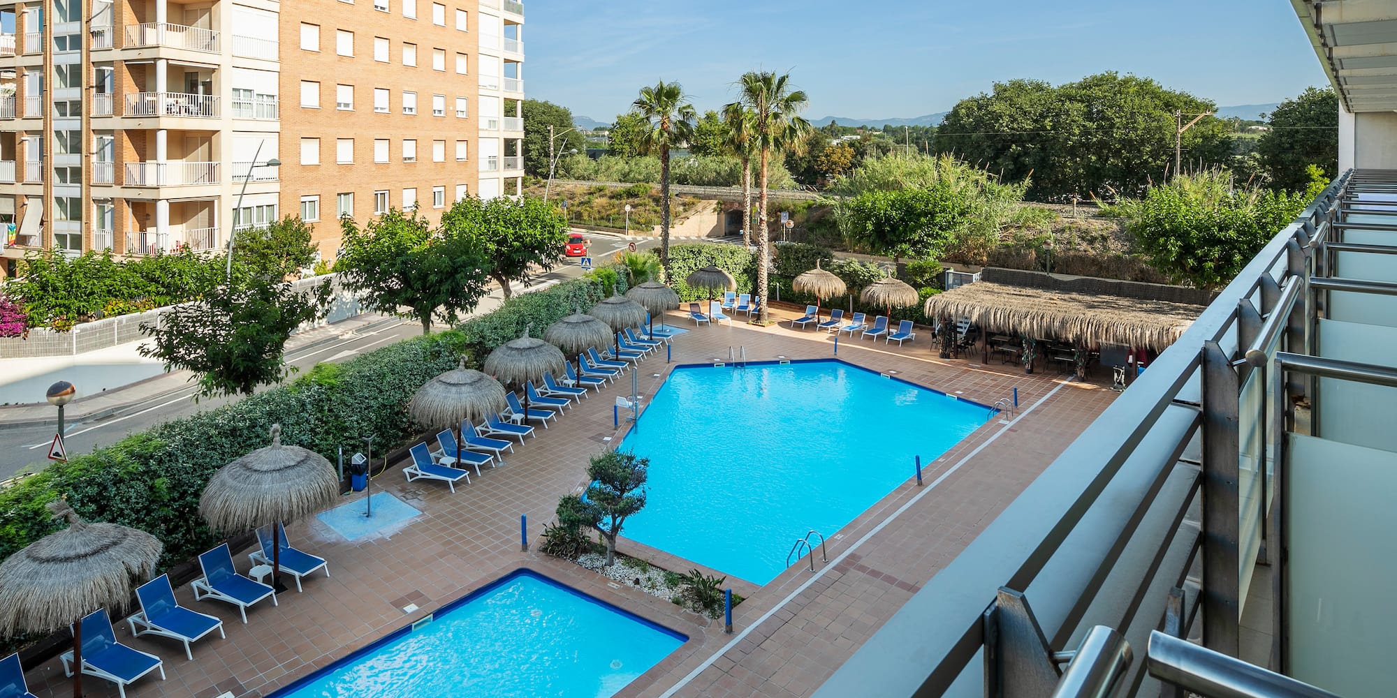 a pool with umbrellas and chairs in a hotel