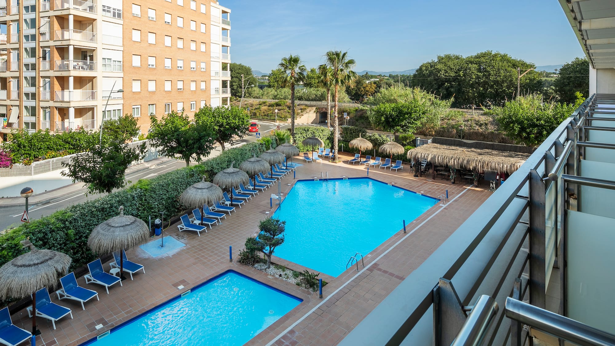 a pool with umbrellas and chairs in a hotel