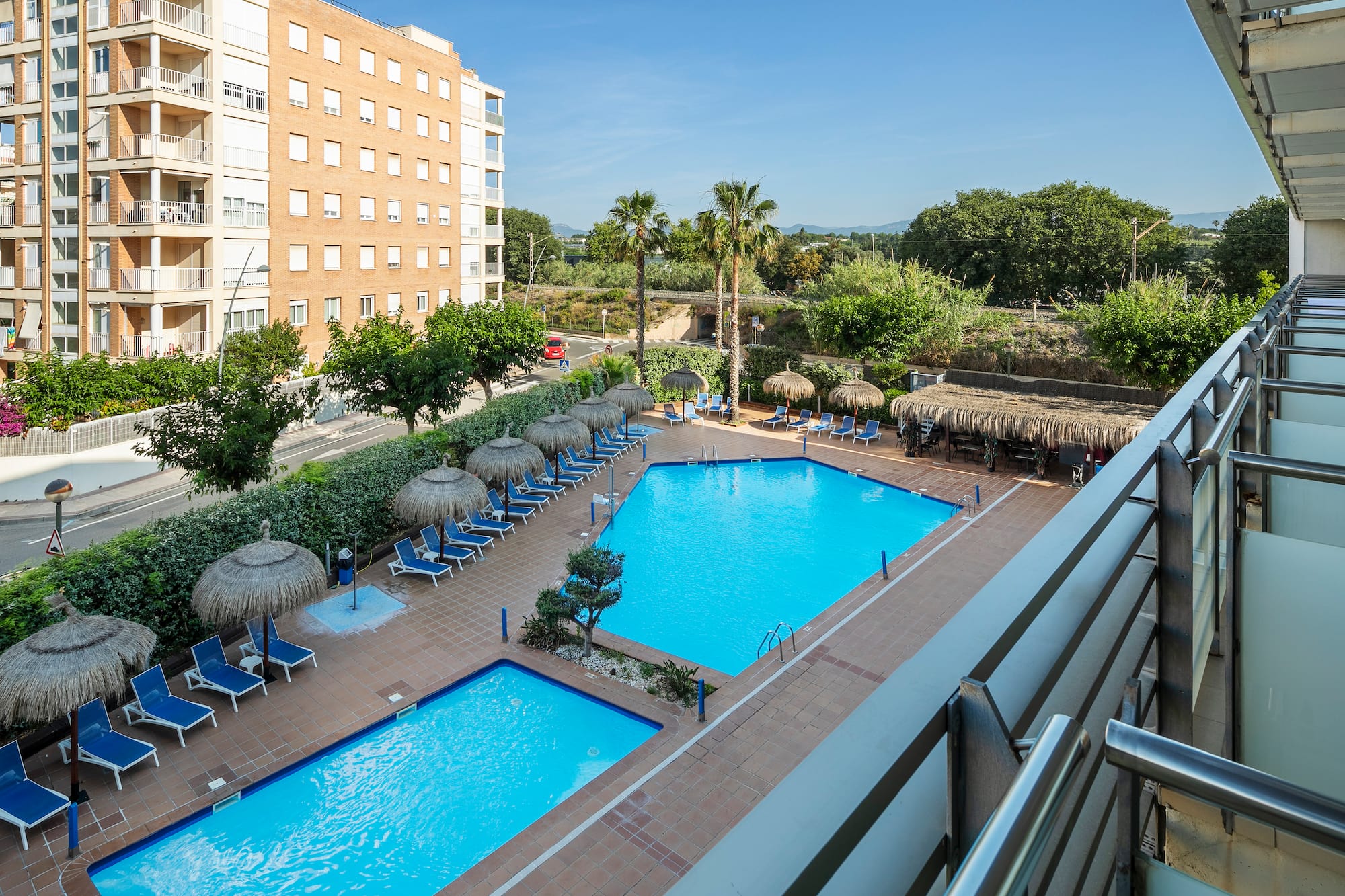 a pool with umbrellas and chairs in a hotel