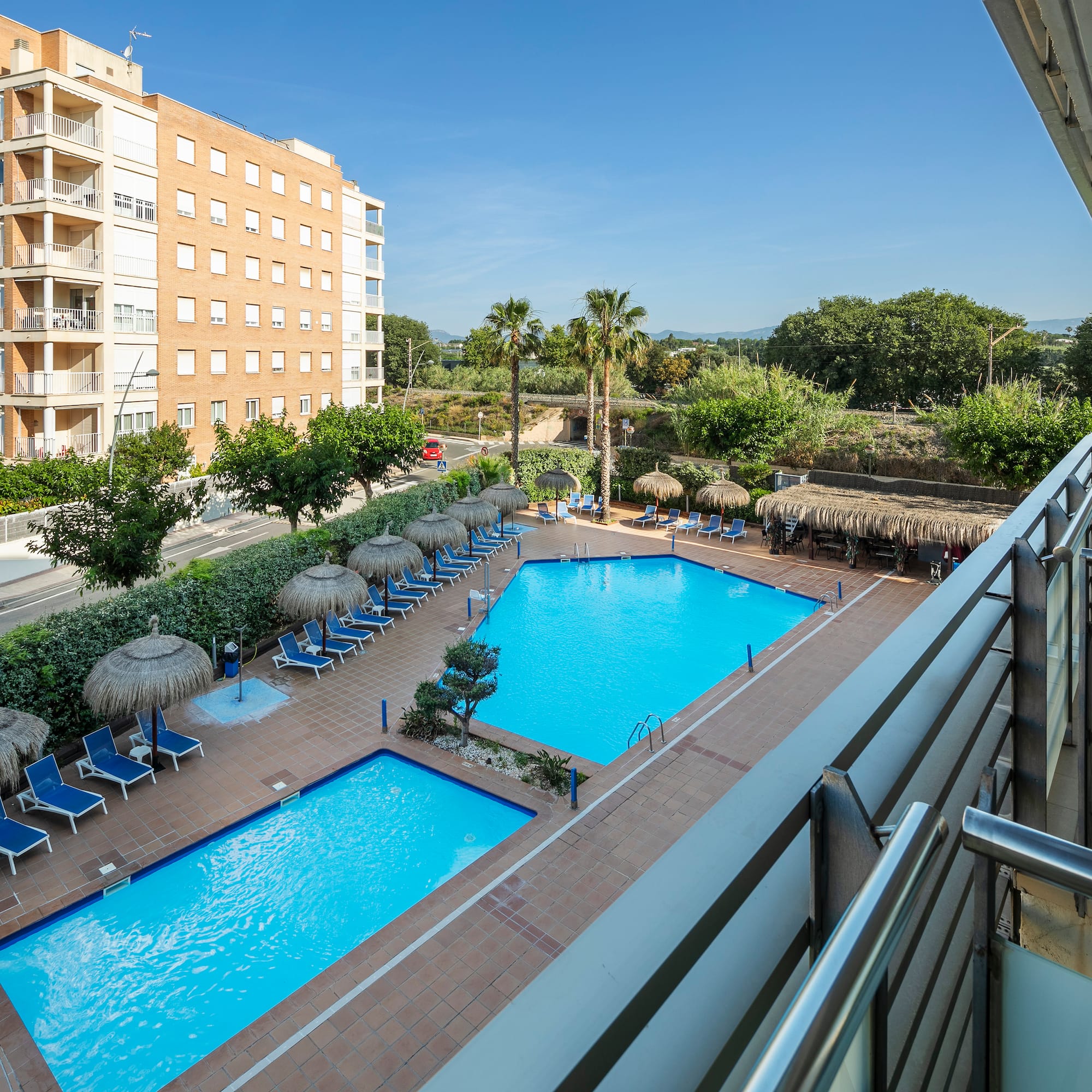 a pool with umbrellas and chairs in a hotel
