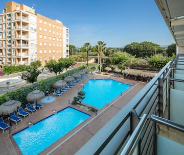 a pool with umbrellas and chairs in a hotel