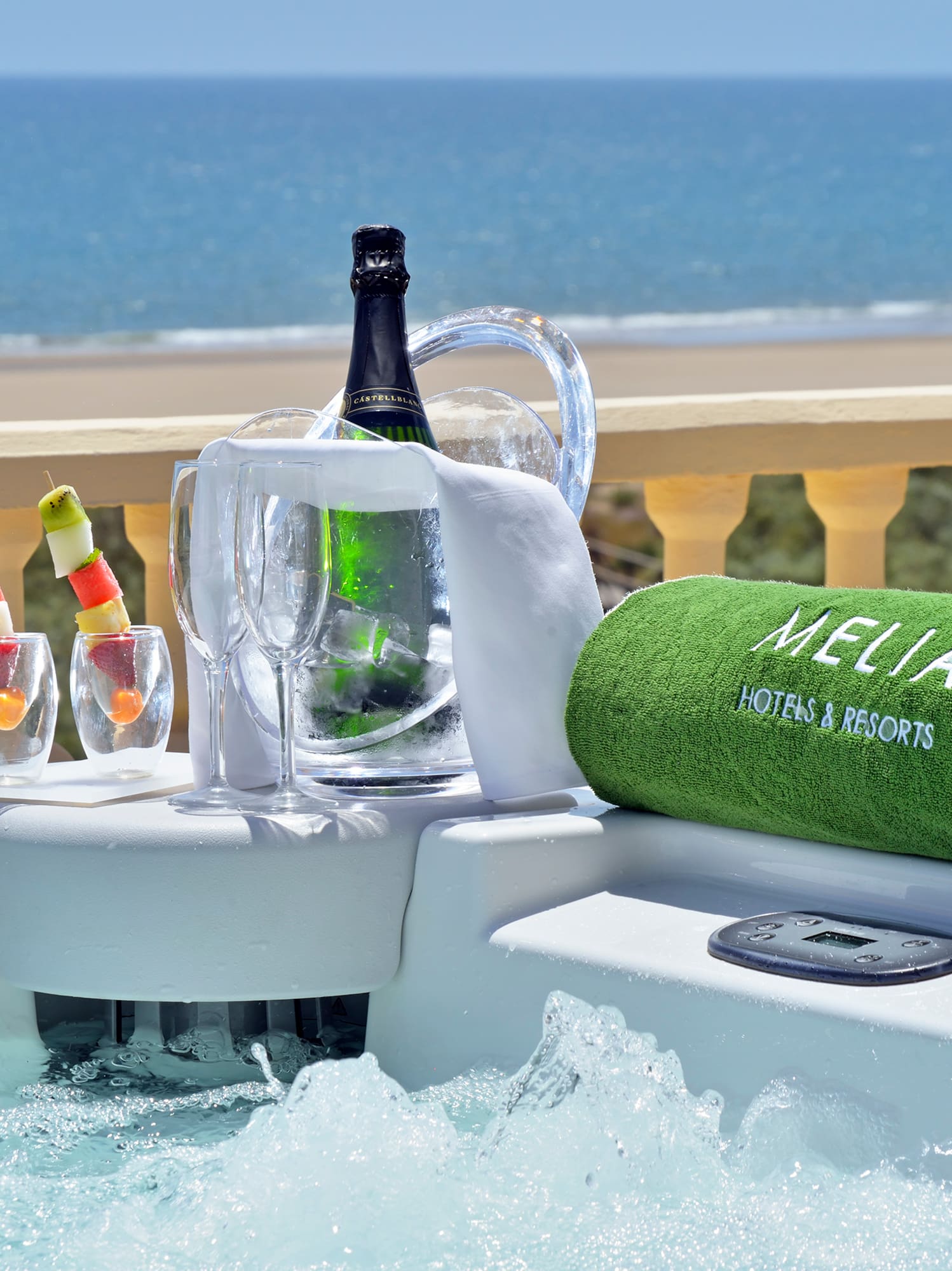 a hot tub with a bottle of wine and glasses on it