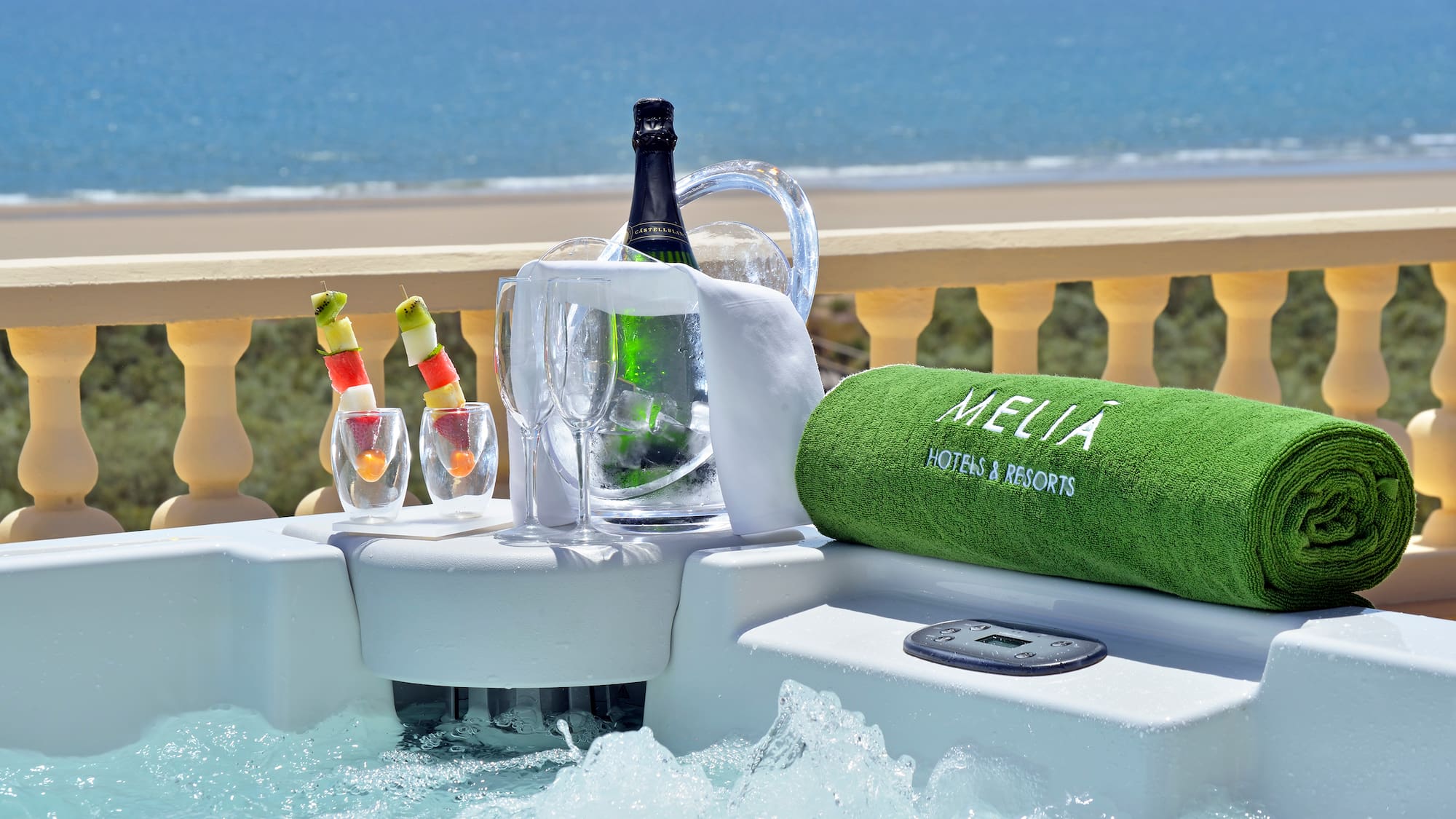 a hot tub with a bottle of wine and glasses on it