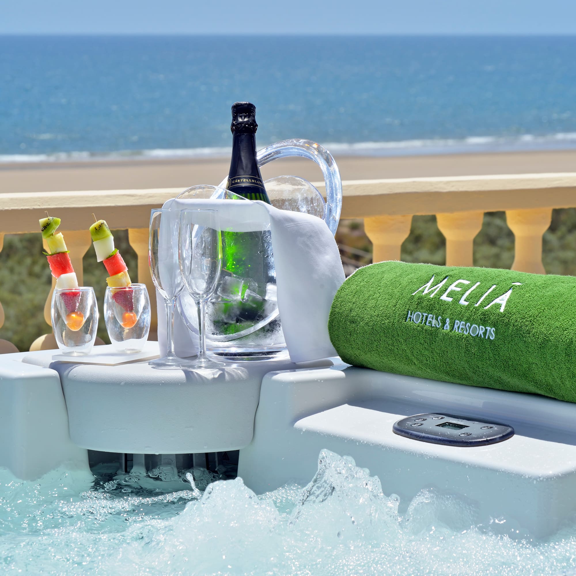 a hot tub with a bottle of wine and glasses on it