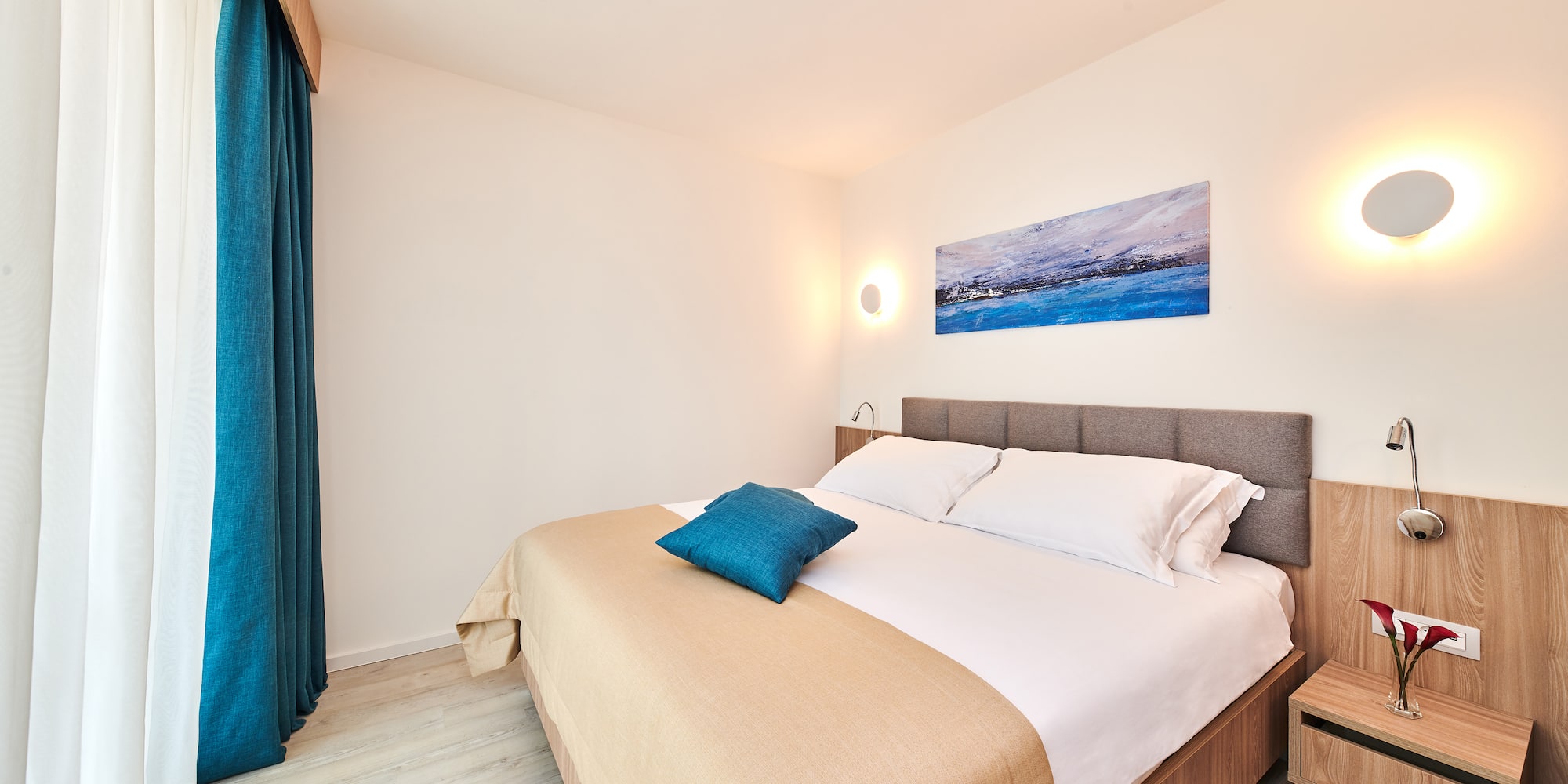 a bed with pillows and a lamp on the wall