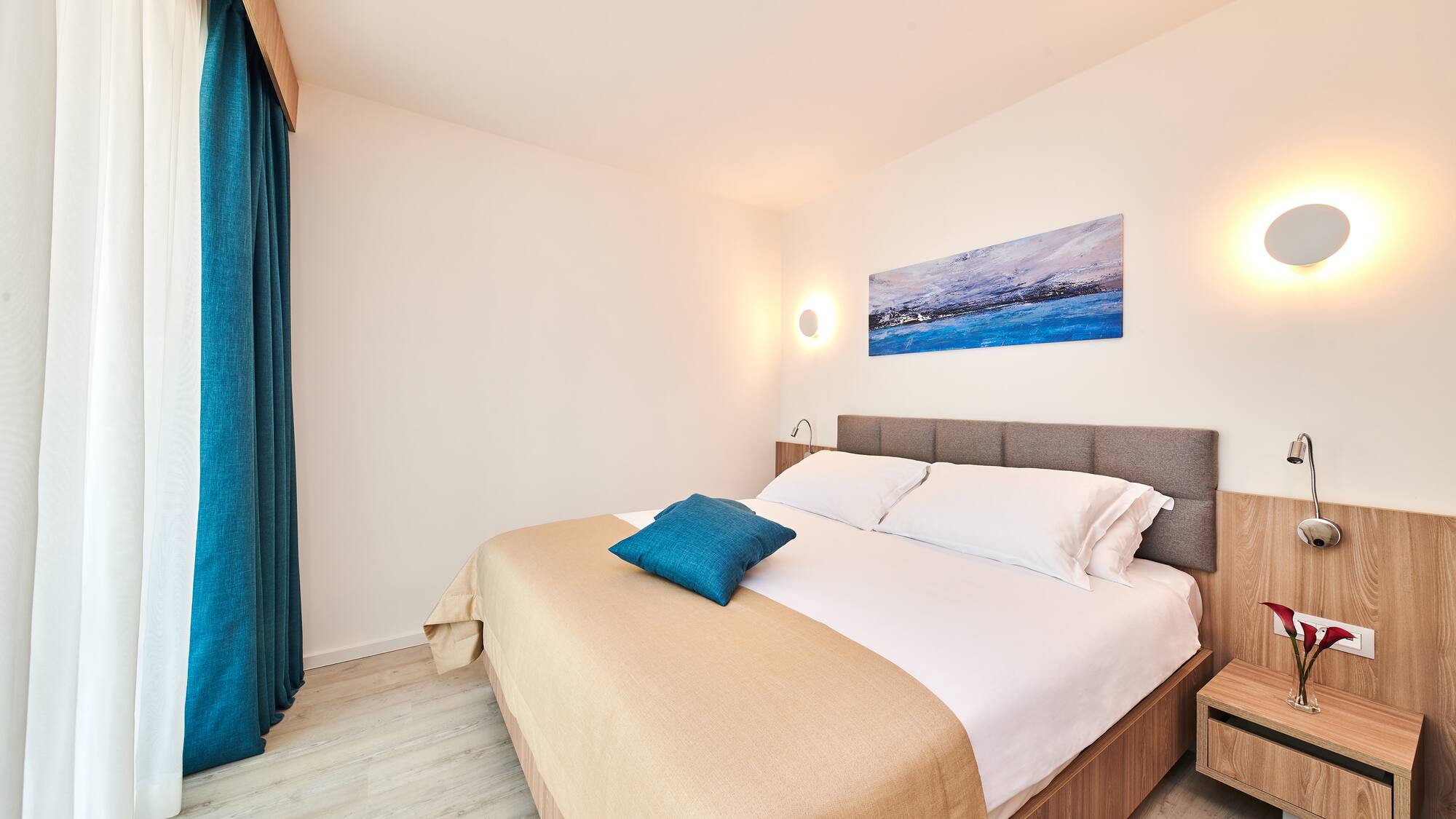 a bed with pillows and a lamp on the wall