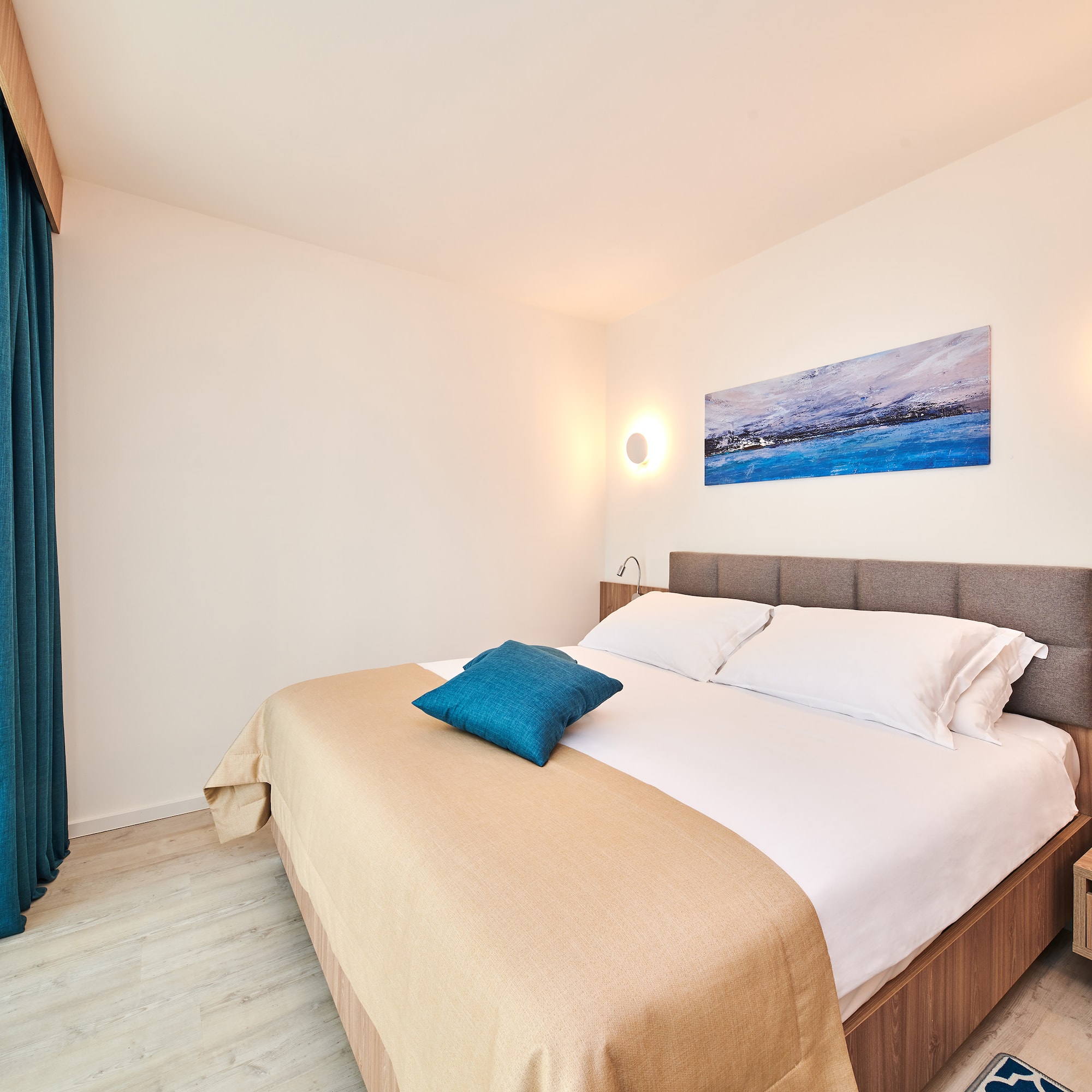 a bed with pillows and a lamp on the wall