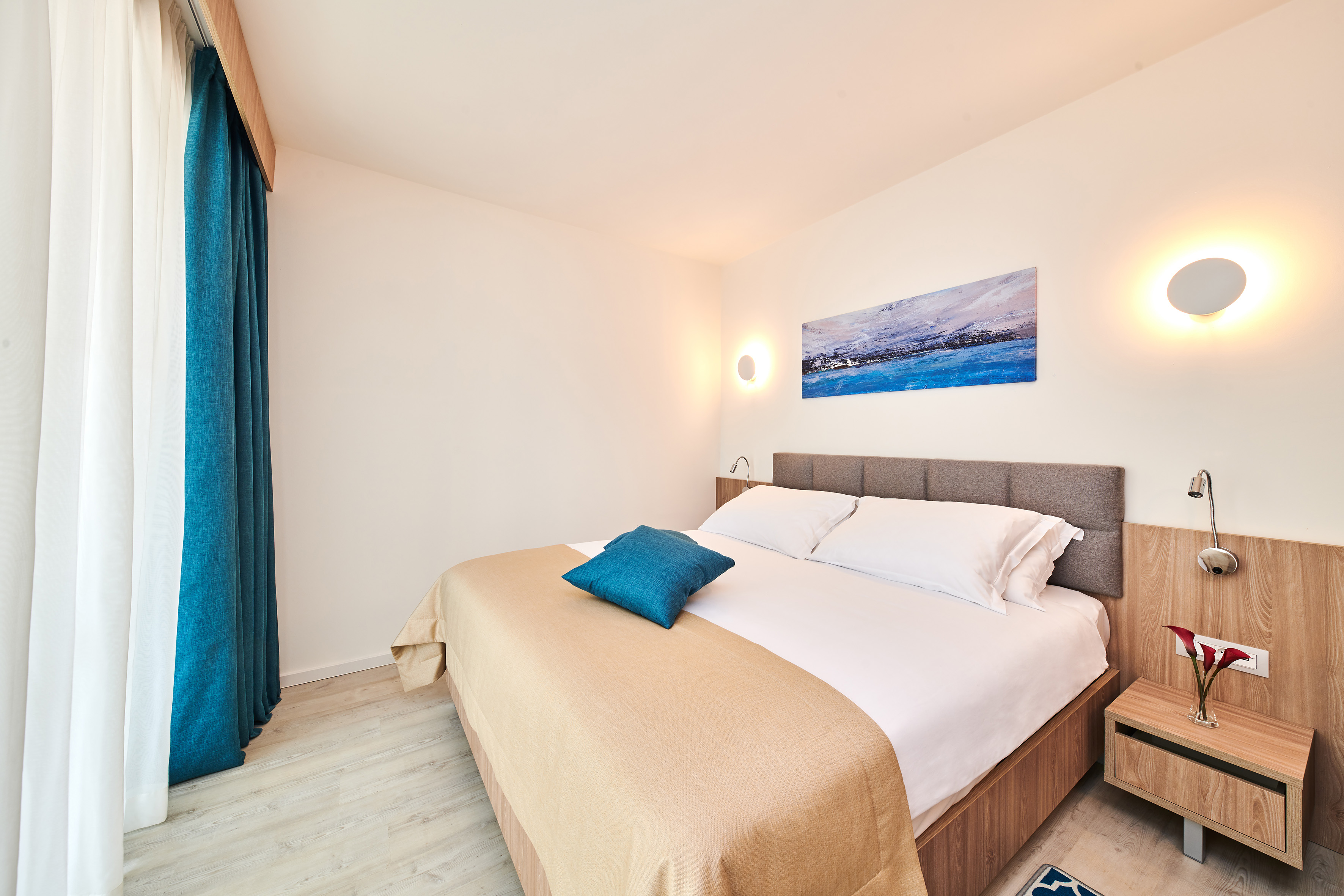 a bed with pillows and a lamp on the wall