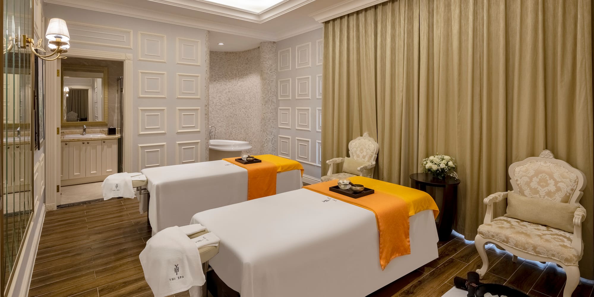 a room with white beds and a wood floor