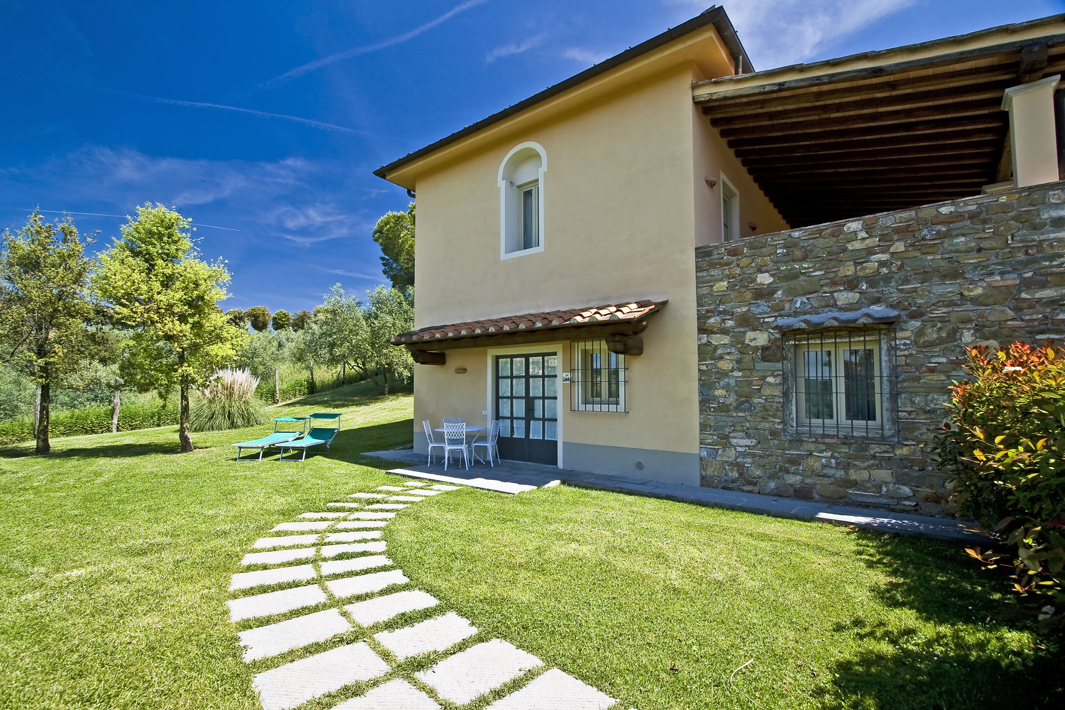 a house with a stone wall and a stone walkway