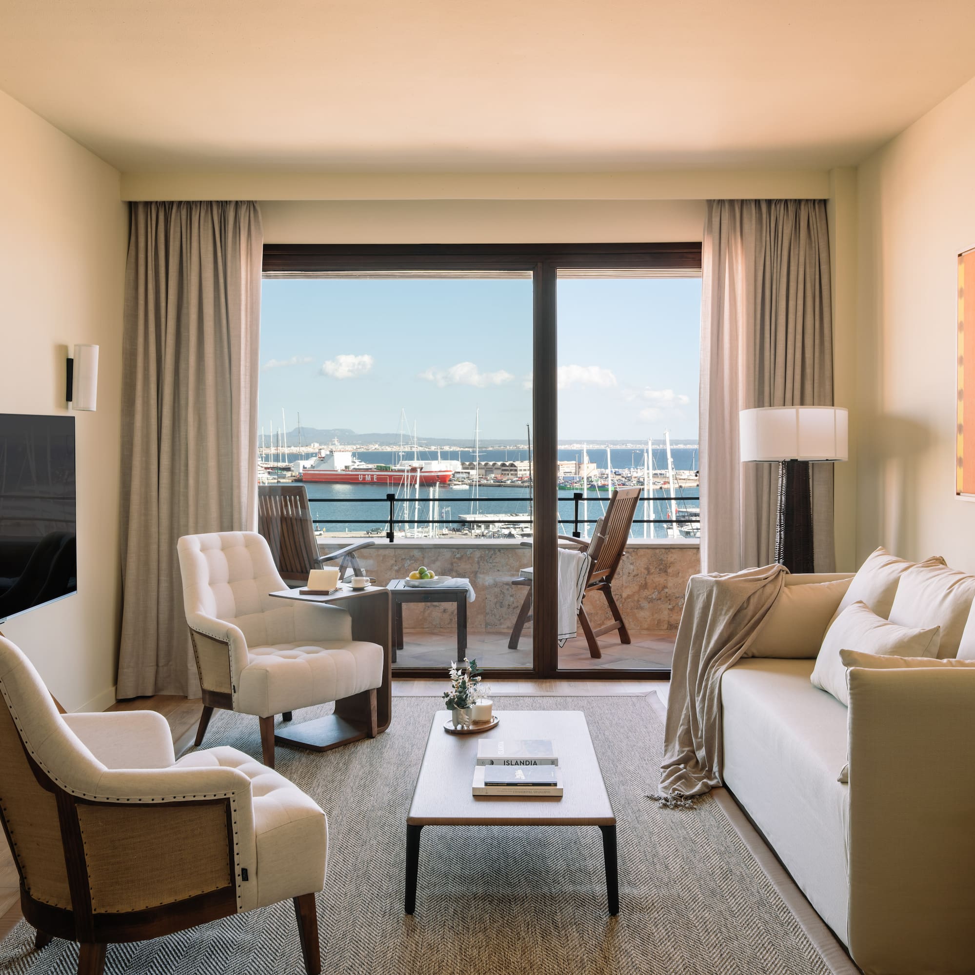 a living room with a view of the water from the balcony
