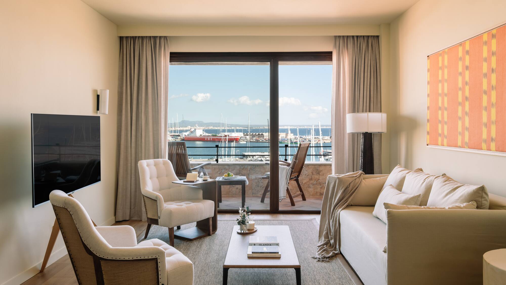 a living room with a view of the water from the balcony