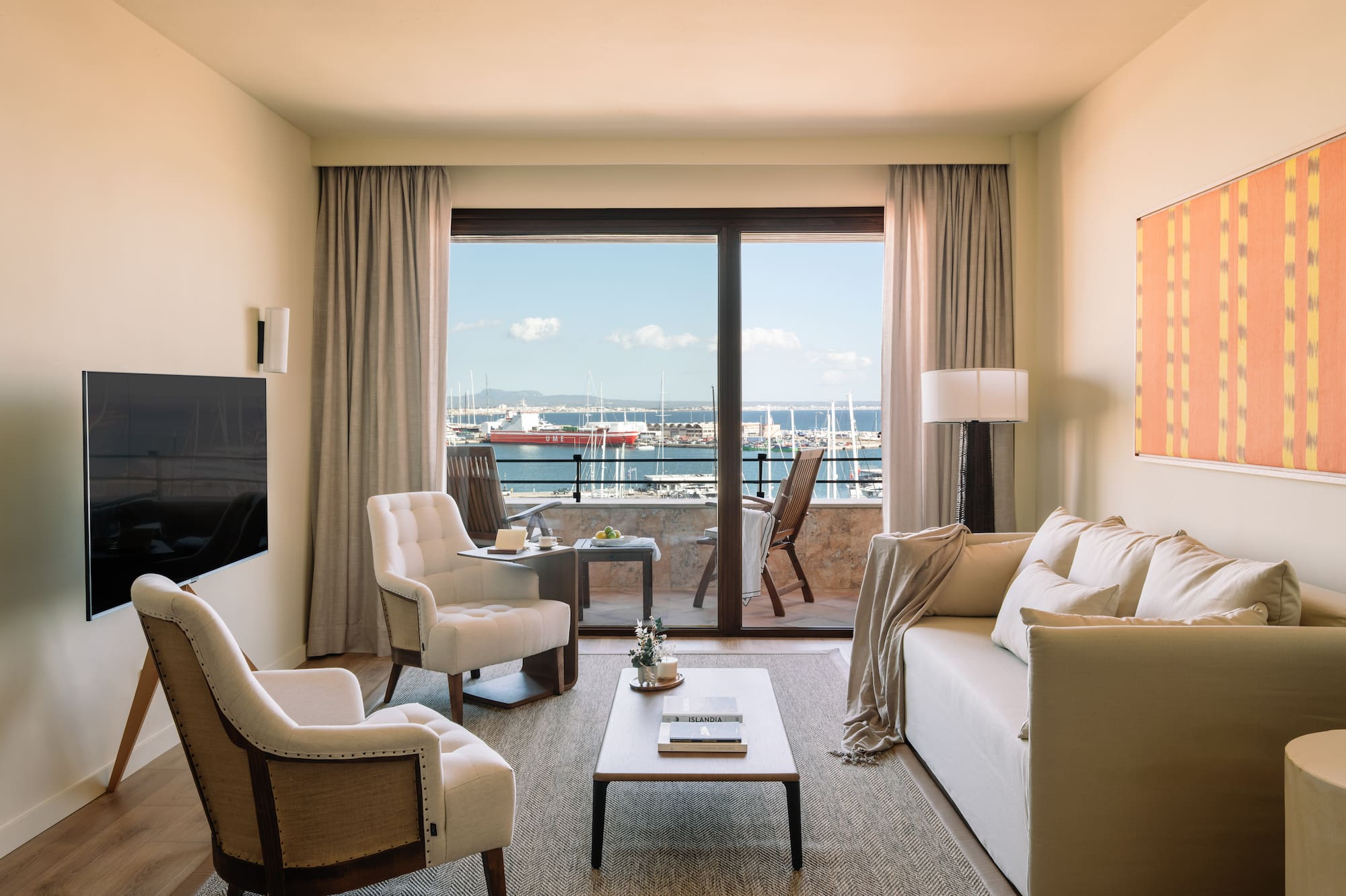 a living room with a view of the water from the balcony