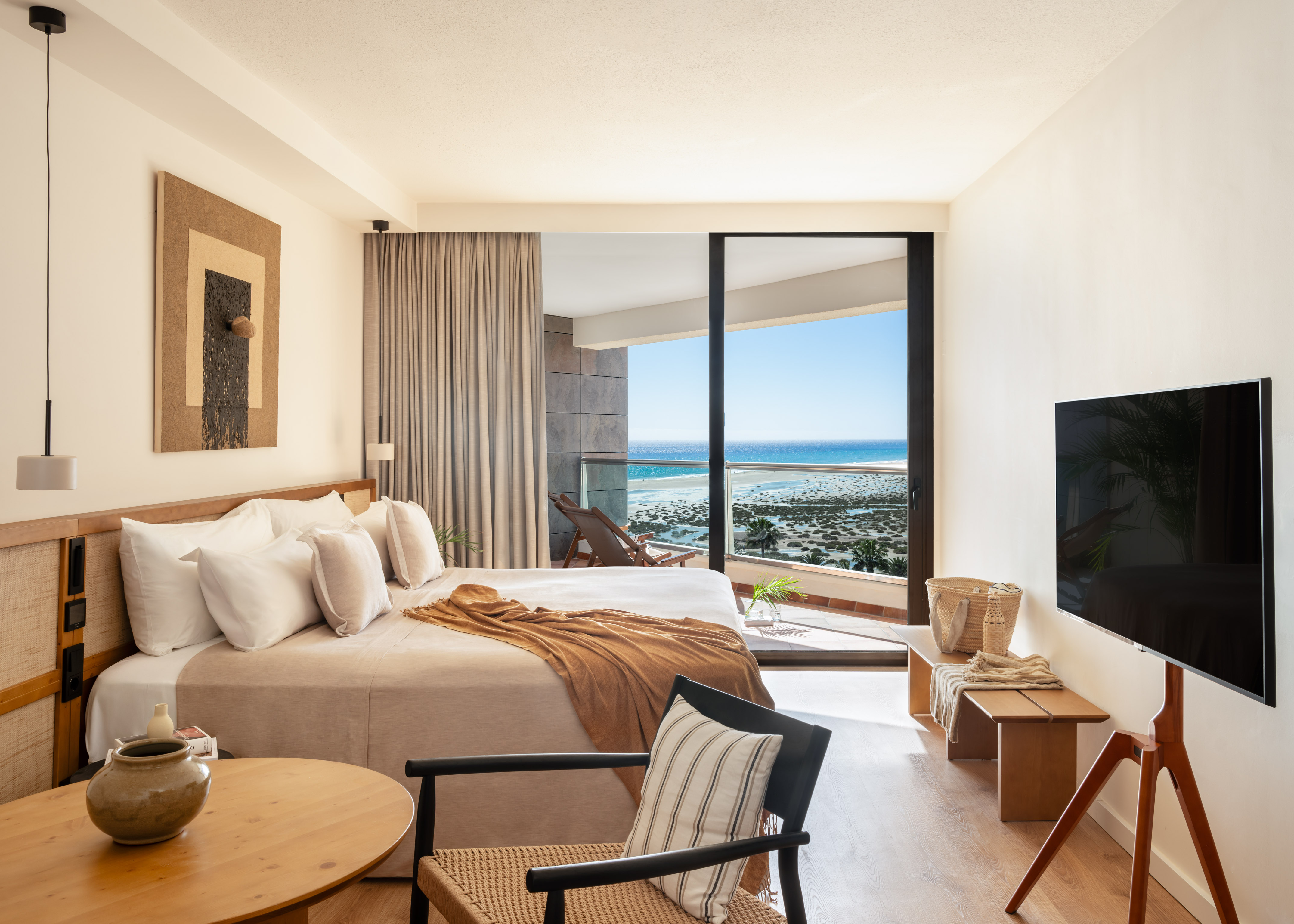 Coastal resort bedroom with sea view balcony and minimalist design.