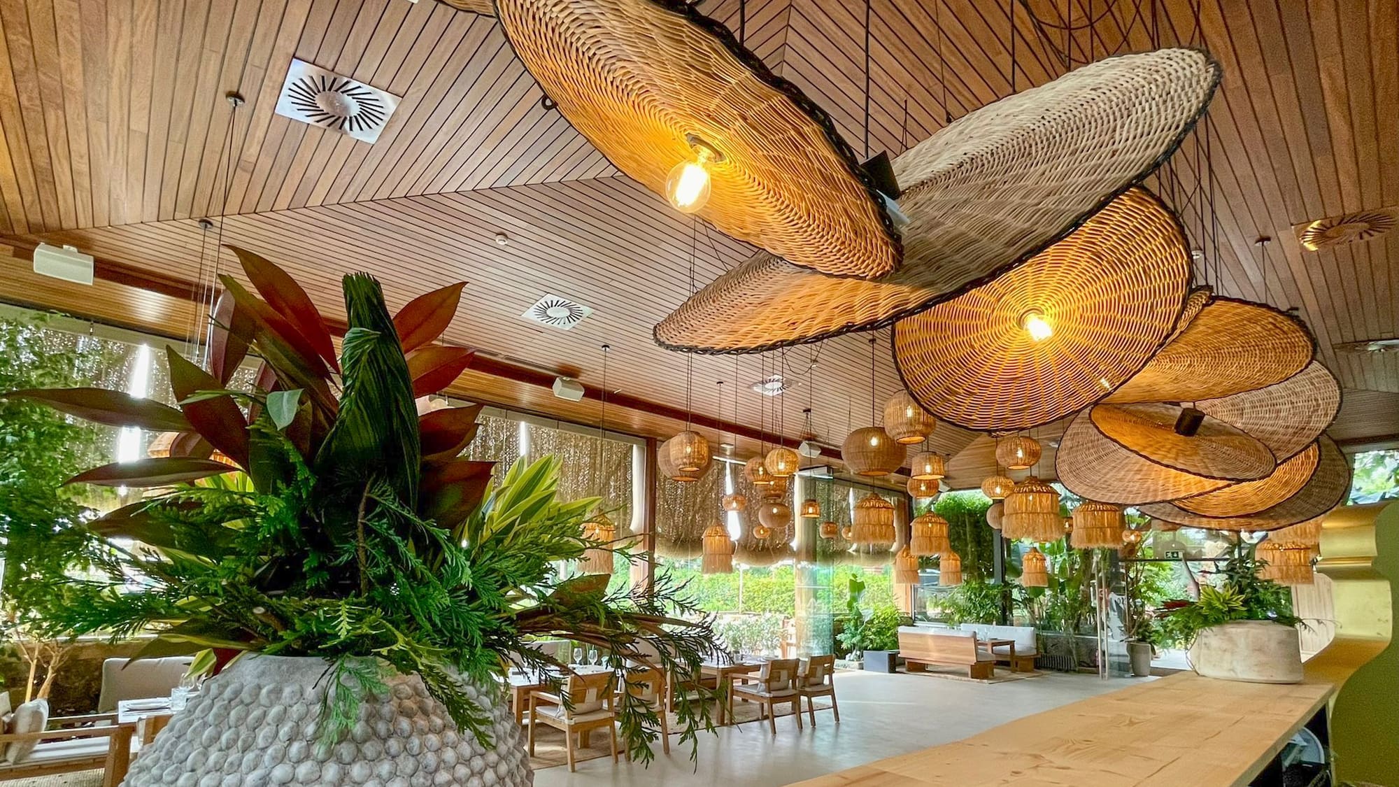 a room with a large table and chairs and a large planter