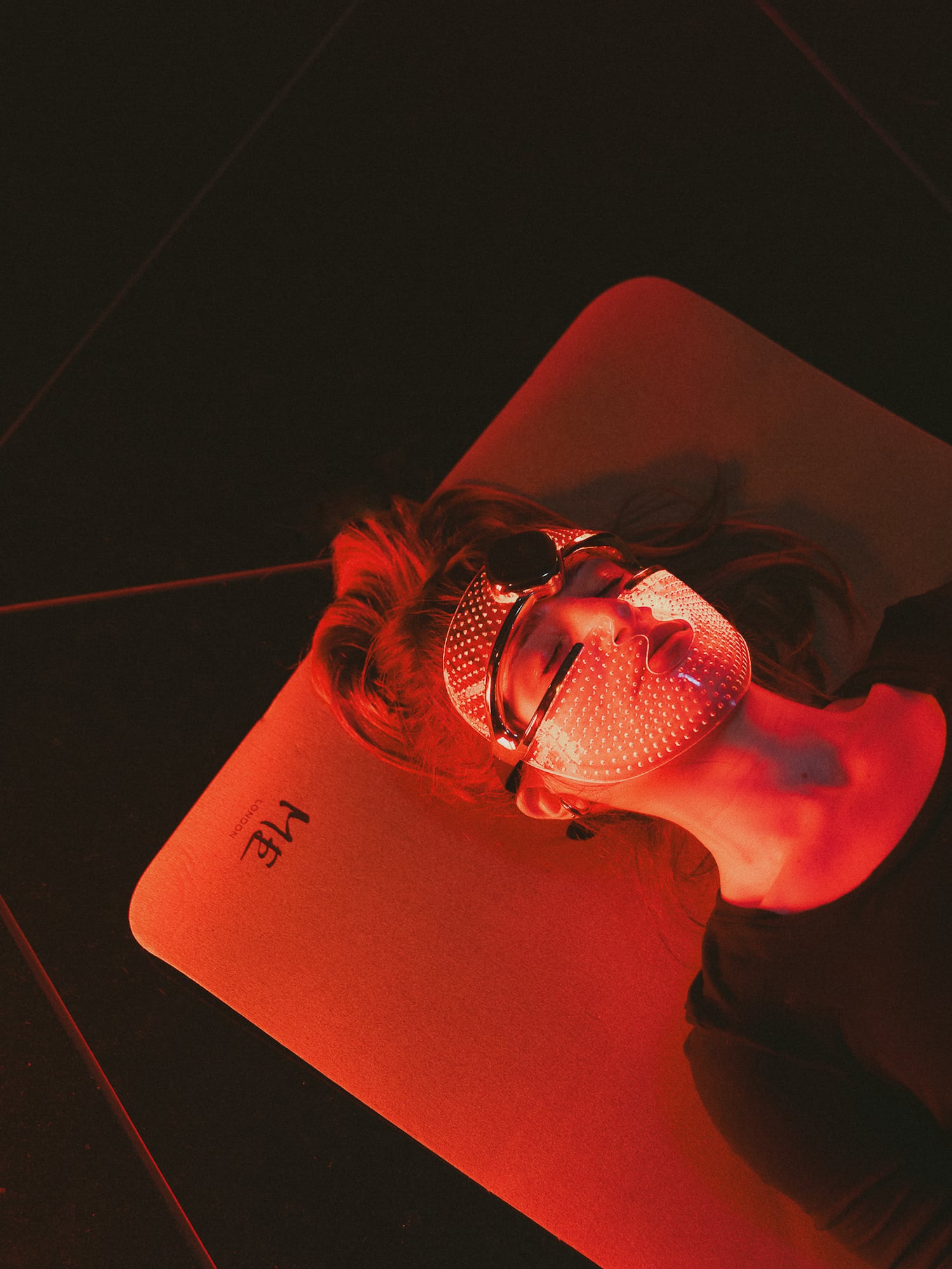 Glowing red light therapy mask on person for anti-aging skincare.