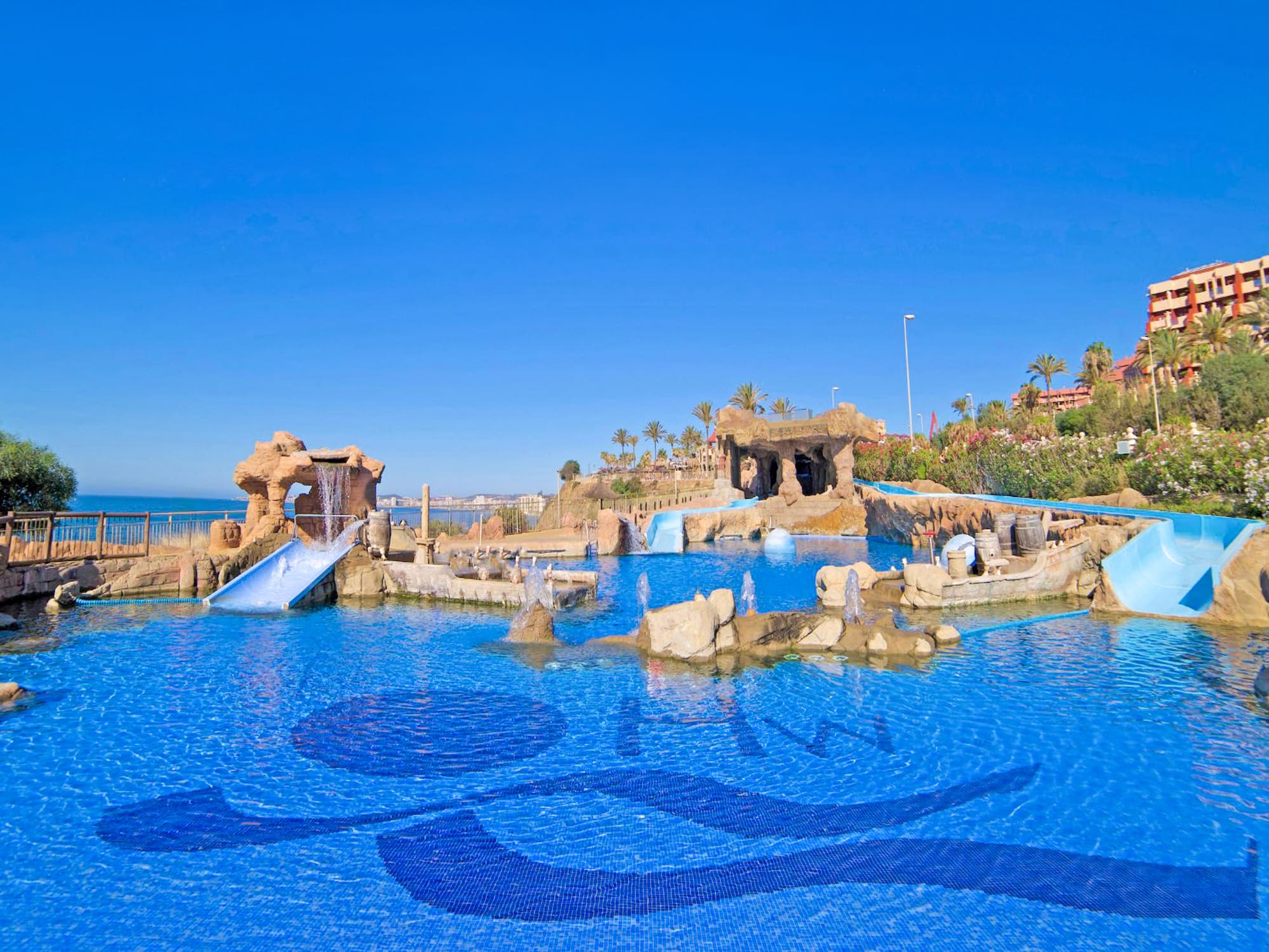 a water park with a slide and a beach