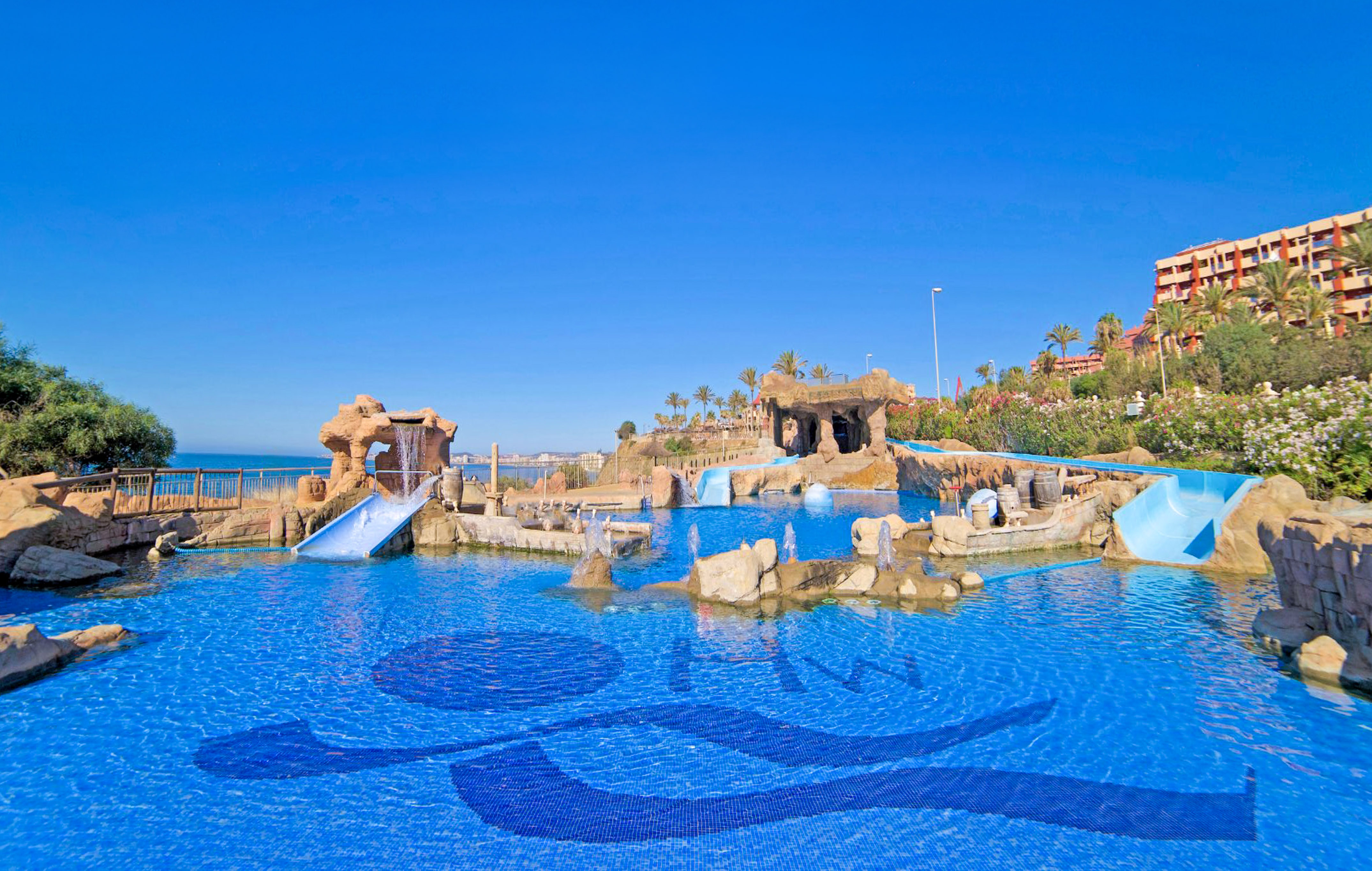 a water park with a slide and a beach