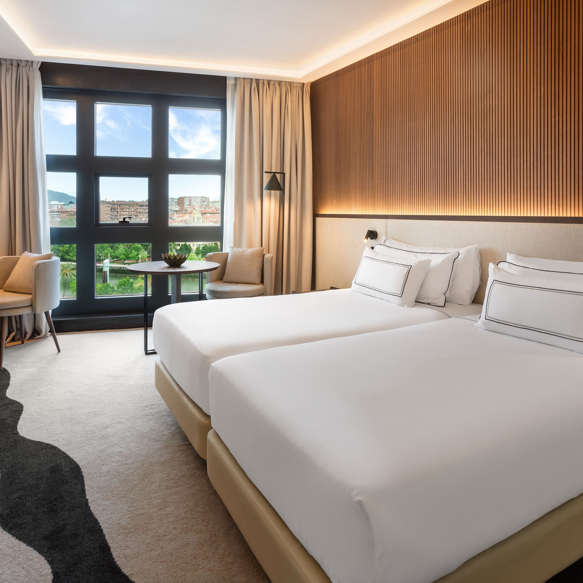 a hotel room with two beds and a table