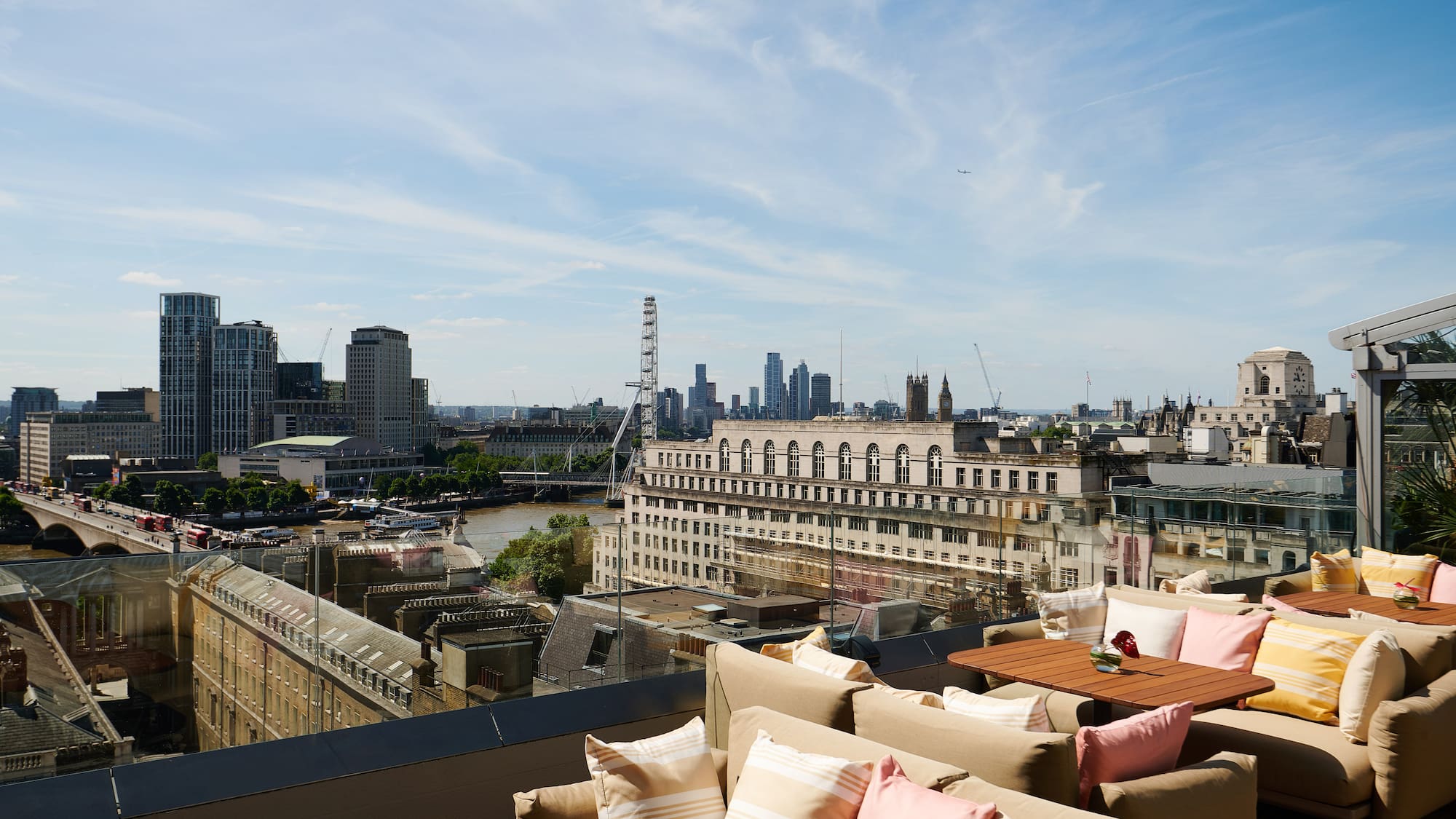 a rooftop bar with a view of a city and a river
