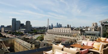 a rooftop bar with a view of a city and a river