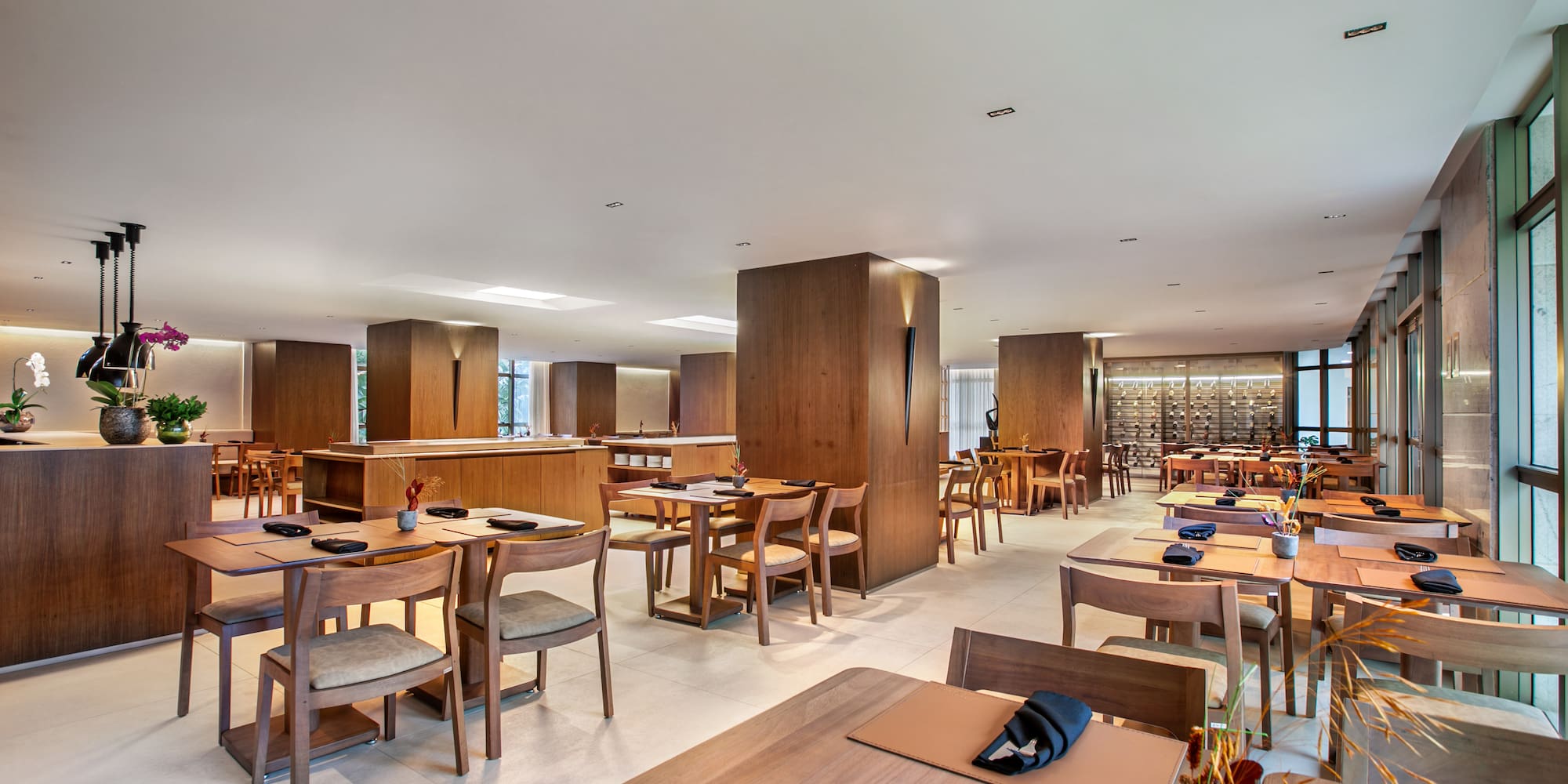 Elegant modern restaurant dining room with wooden tables and chairs.