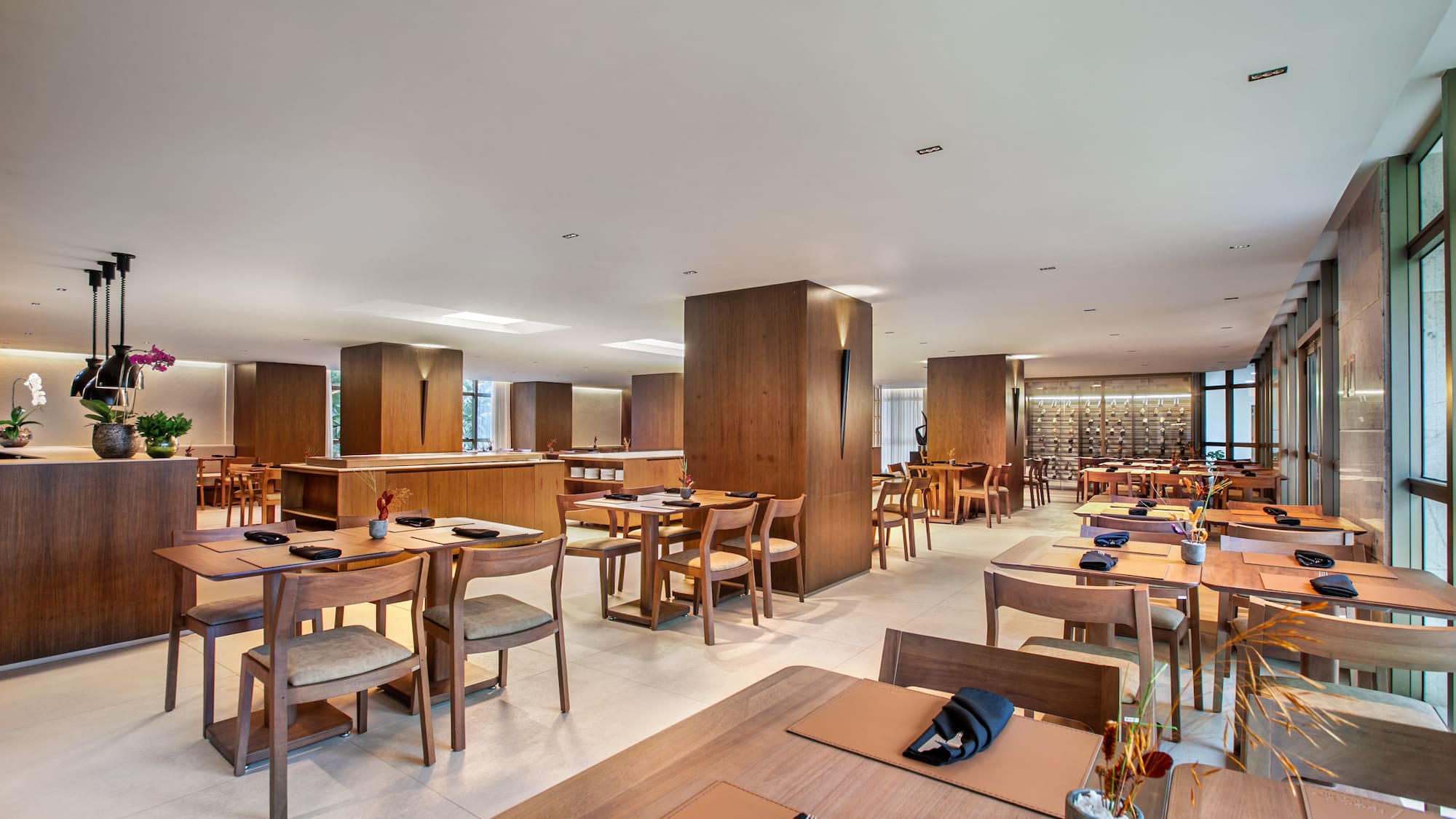 Elegant modern restaurant dining room with wooden tables and chairs.