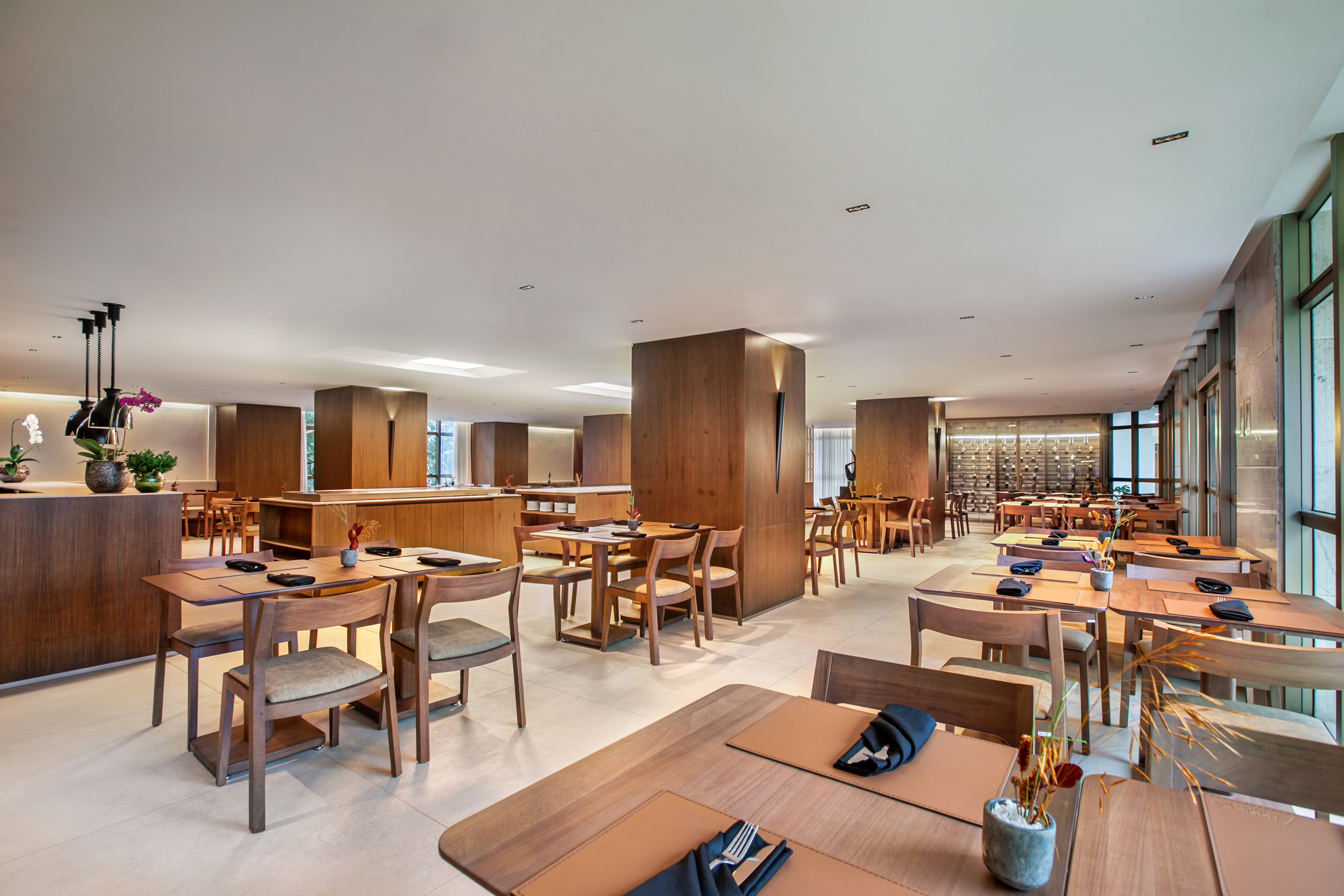 Elegant modern restaurant dining room with wooden tables and chairs.