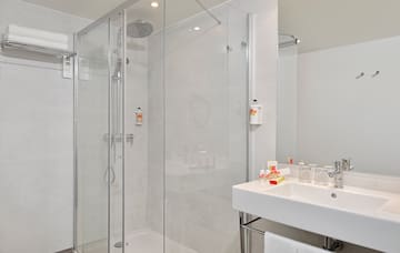 a bathroom with a glass shower and sink