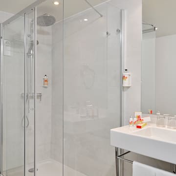 a bathroom with a glass shower and sink