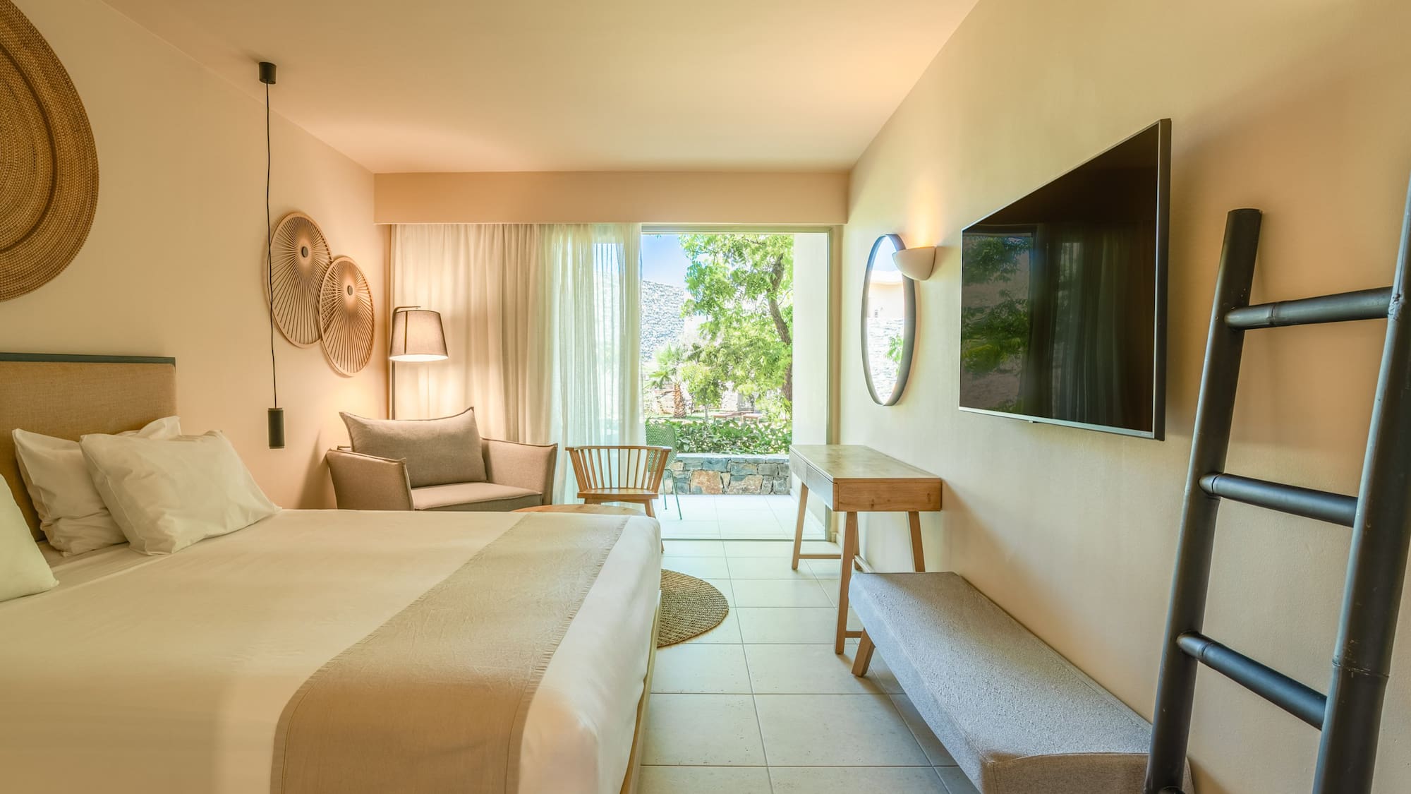 Stylish hotel bedroom with private balcony, garden view, and modern decor.