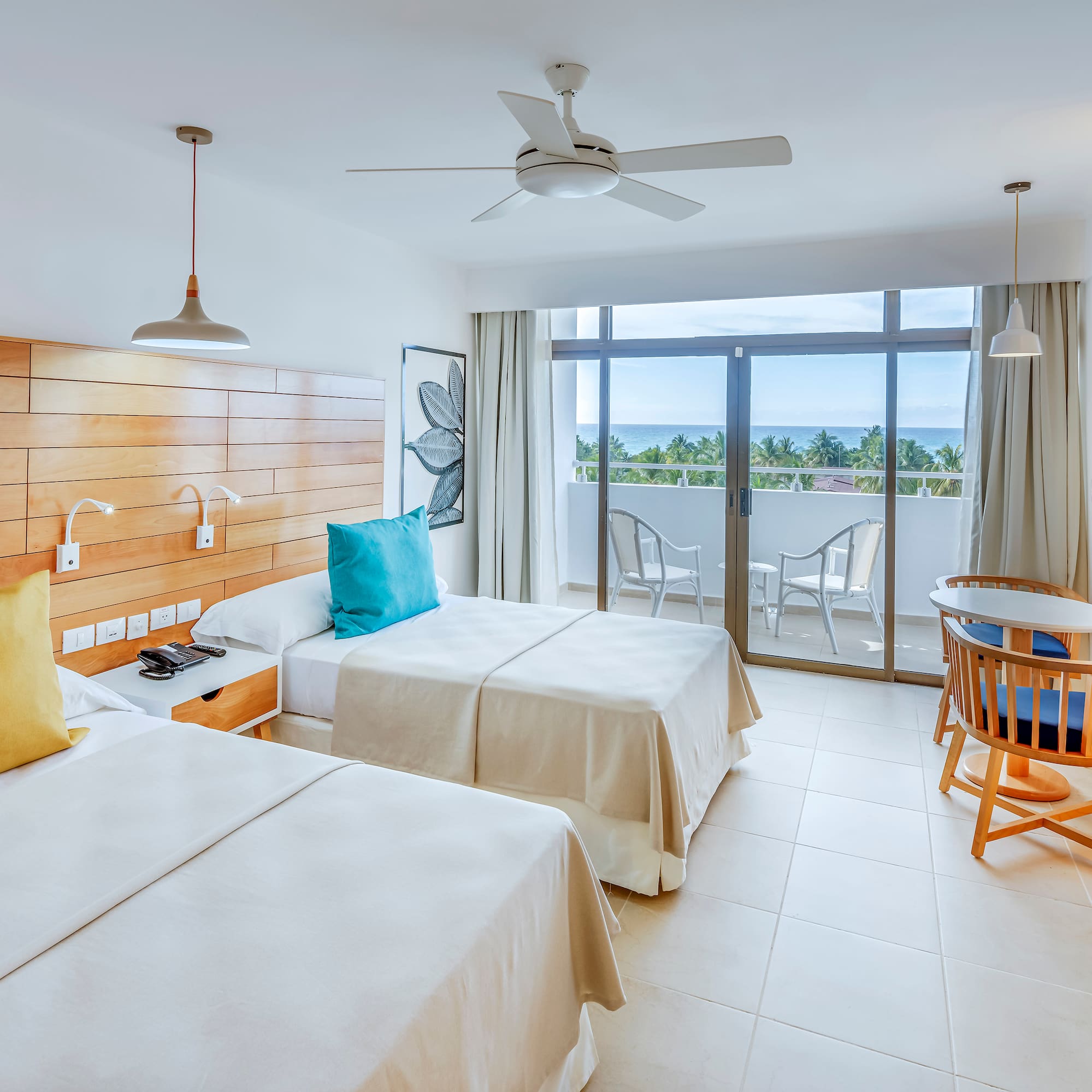 a room with two beds and a table and chairs