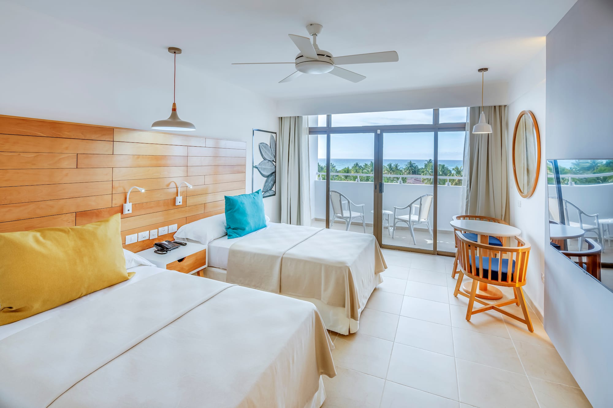 a room with two beds and a table and chairs