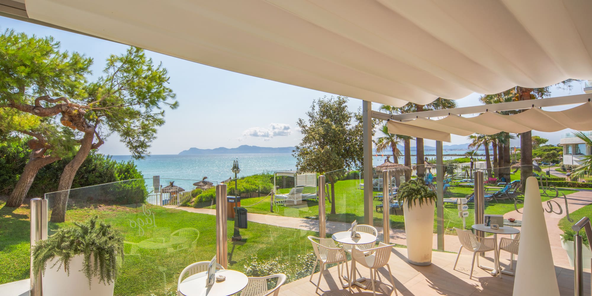 a patio with chairs and tables and a view of the ocean